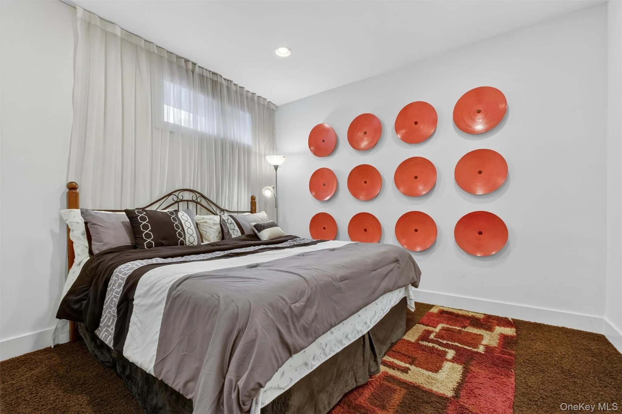 Flexible lower-level guest retreat with king-size bed setup and designer accent wall. Flexible lower-level guest retreat with king-size bed setup and designer accent wall.