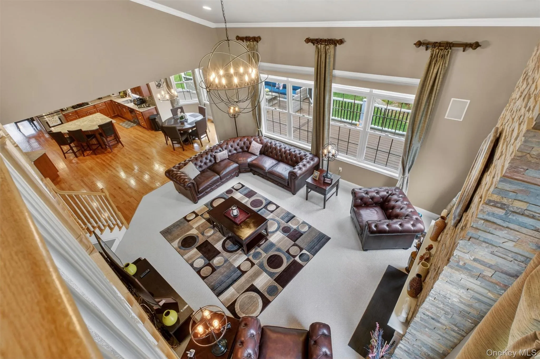 Upper-level overlook showcasing the two-story family room, custom draperies, and window treatments. Upper-level overlook showcasing the two-story family room, custom draperies, and window treatments.