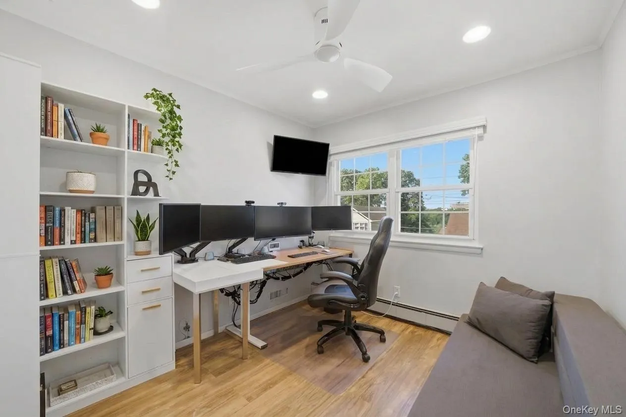 Bright 3rd bedroom featuring a large window, recessed lighting, and wood-finish flooring Bright 3rd bedroom featuring a large window, recessed lighting, and wood-finish flooring