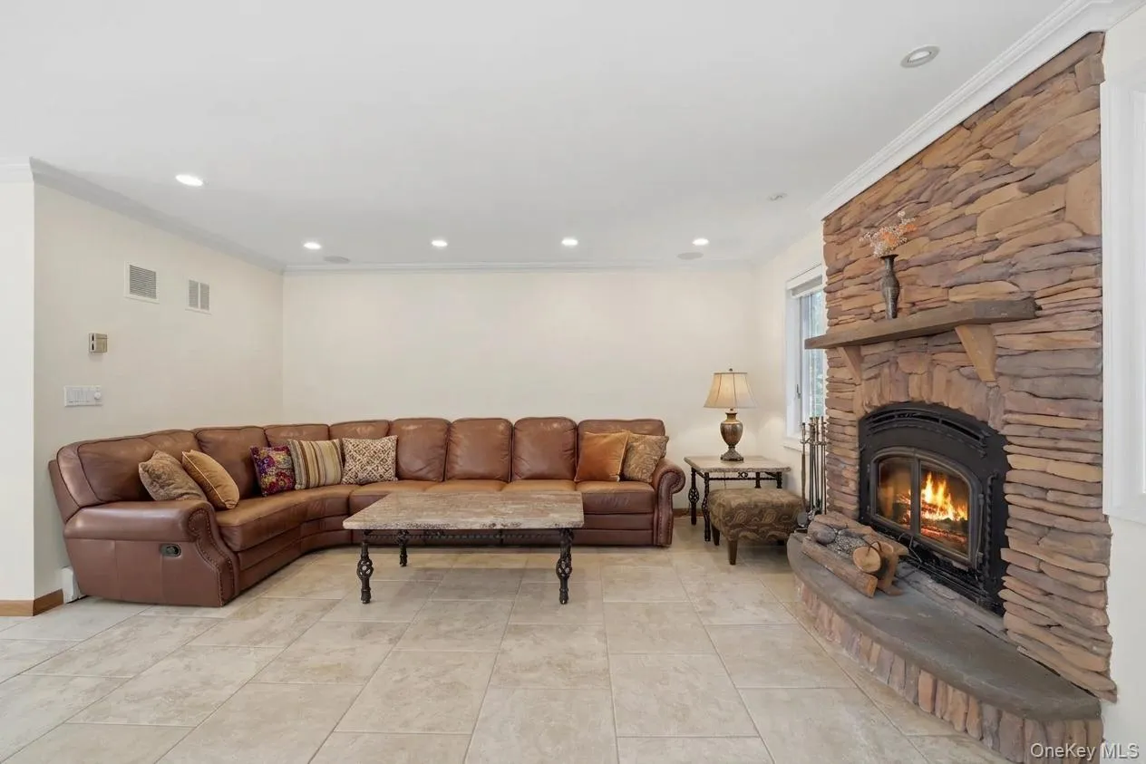 Stacked stone fireplace with a raised hearth and wood mantel Stacked stone fireplace with a raised hearth and wood mantel