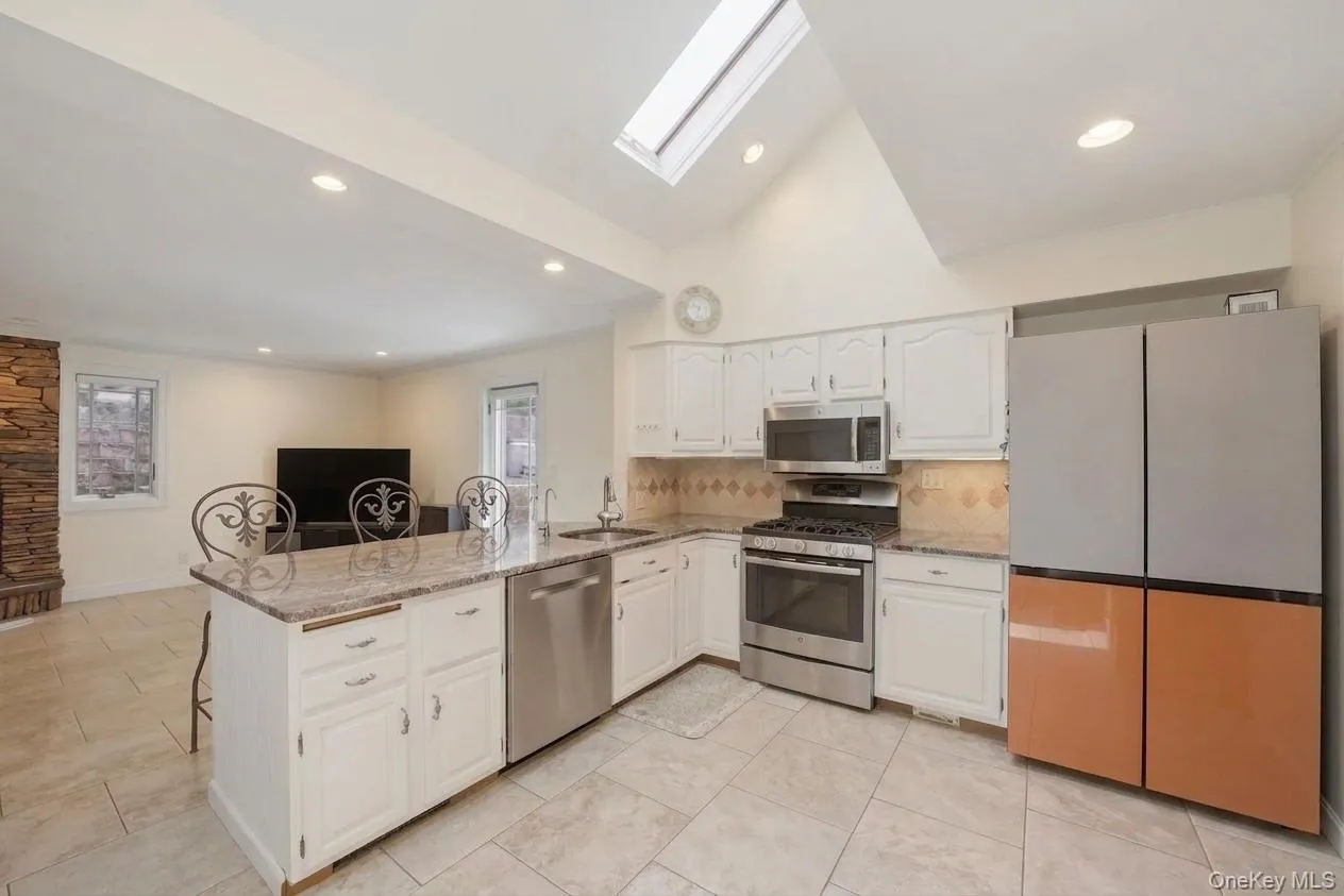 Open-concept kitchen with white cabinetry and granite countertops Open-concept kitchen with white cabinetry and granite countertops