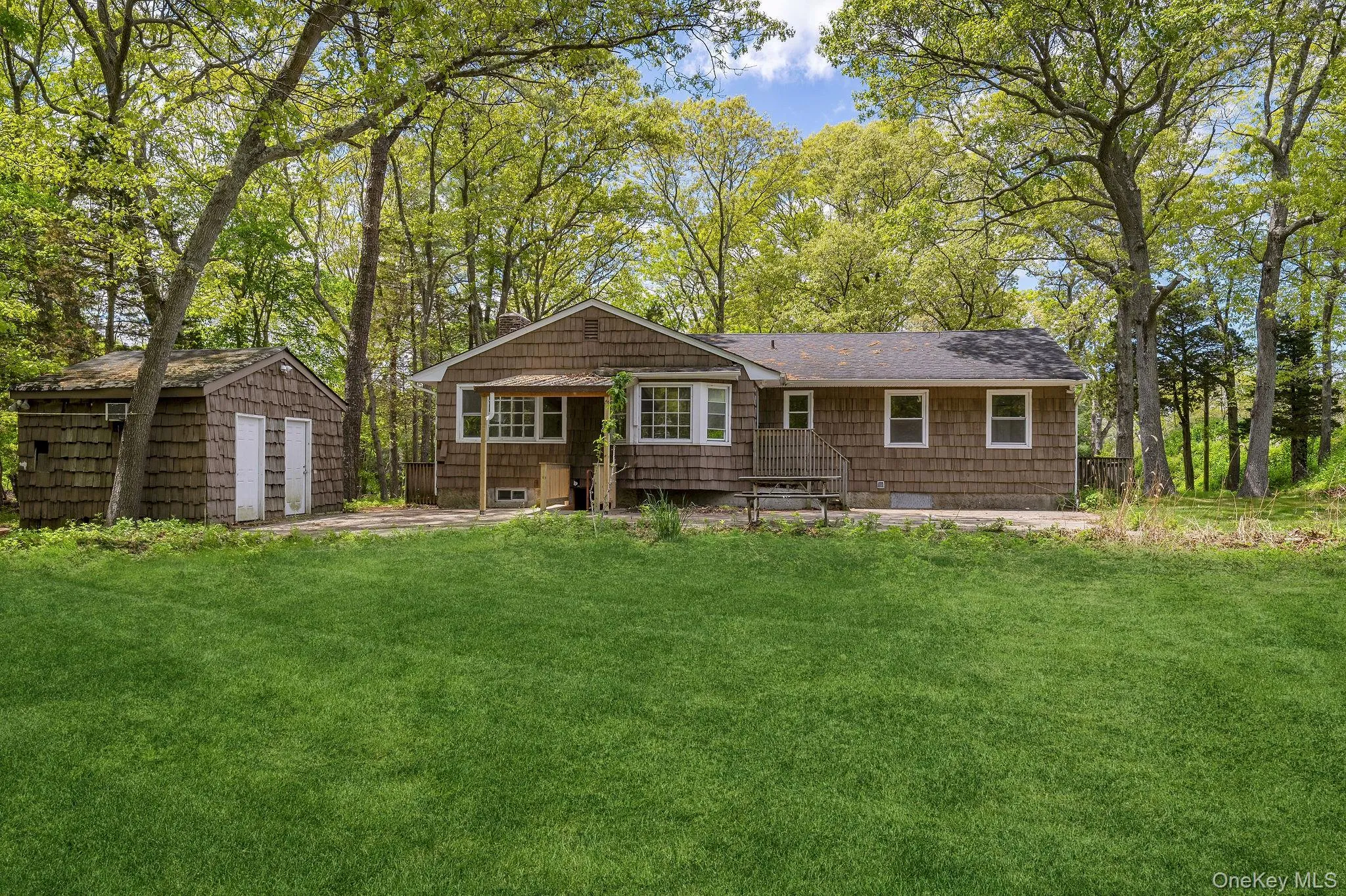Ranch-style residence featuring shake siding and a gabled roof Ranch-style residence featuring shake siding and a gabled roof