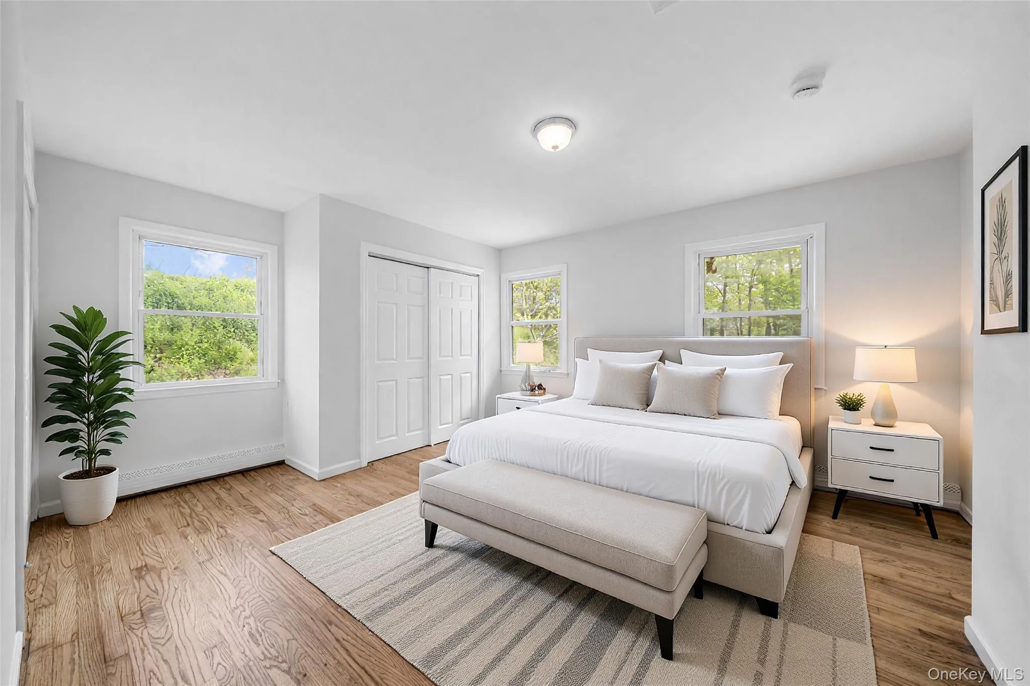 Spacious room featuring wood-finish flooring, light-toned walls, and multiple windows. Image is Virtually Staged. Spacious room featuring wood-finish flooring, light-toned walls, and multiple windows. Image is Virtually Staged.