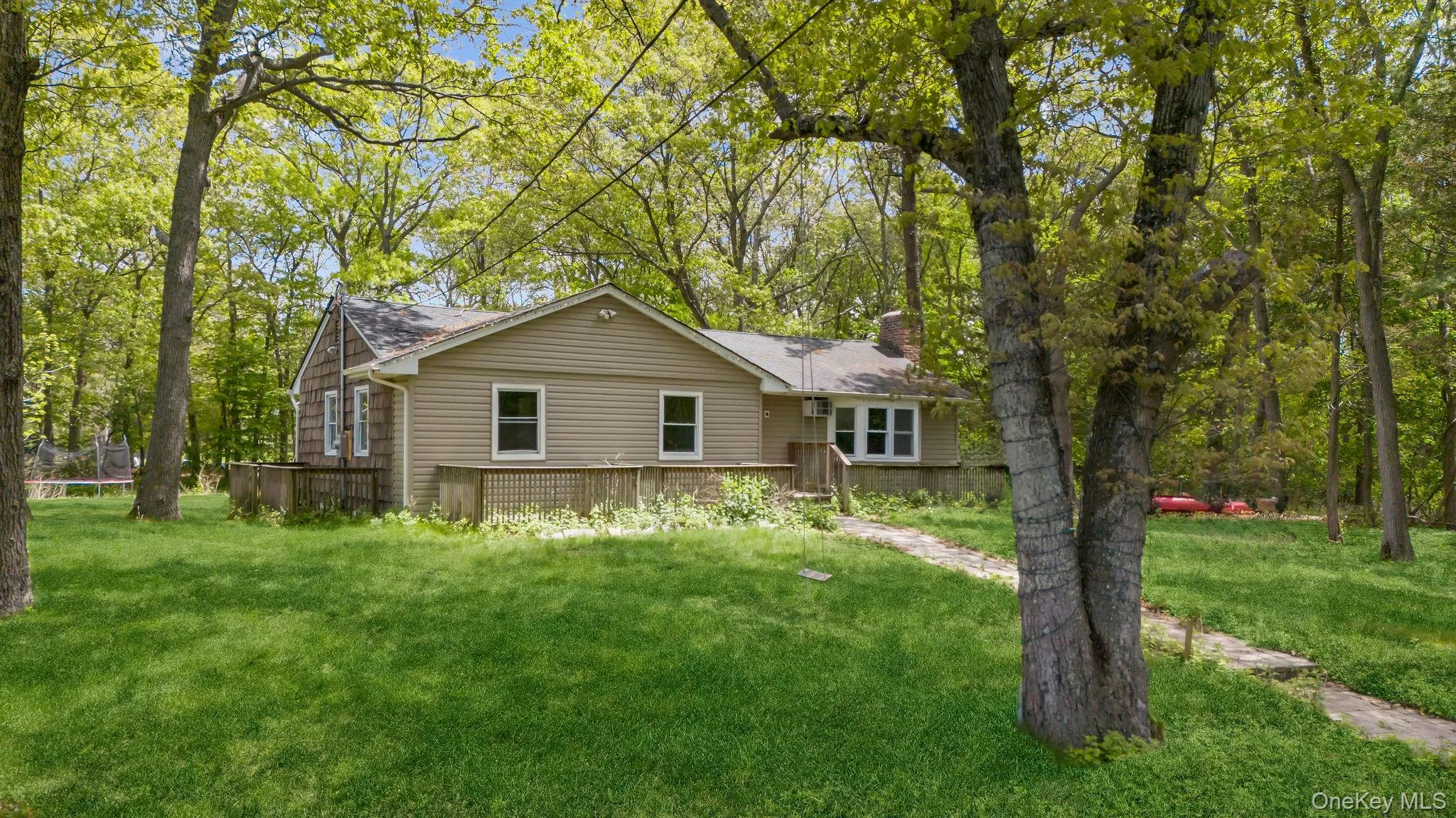 Ranch-style exterior with neutral siding and a front deck Ranch-style exterior with neutral siding and a front deck