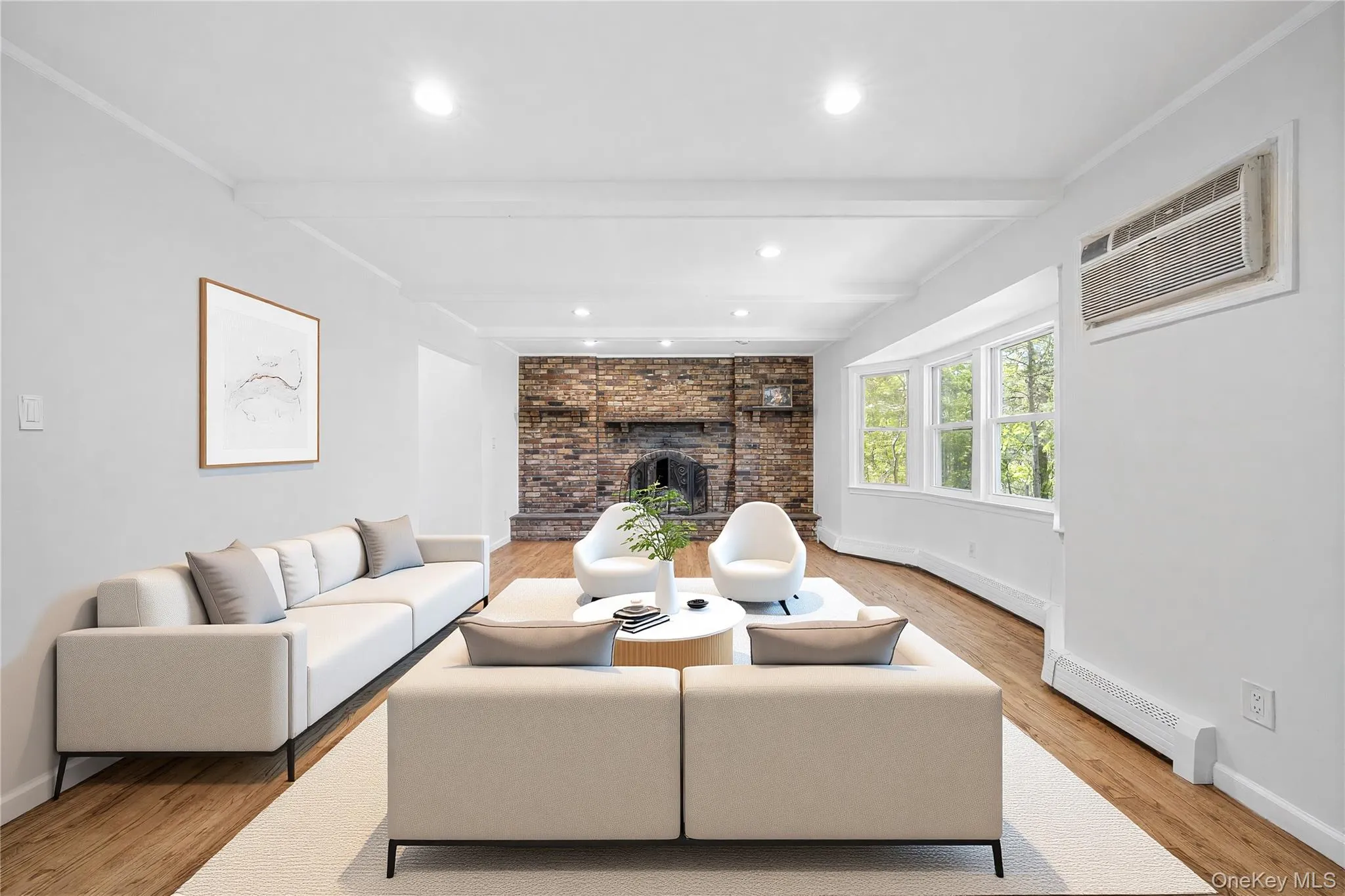 Living area featuring wood-finish flooring, recessed lighting, and a brick fireplace. Image is Virtually Staged. Living area featuring wood-finish flooring, recessed lighting, and a brick fireplace. Image is Virtually Staged.