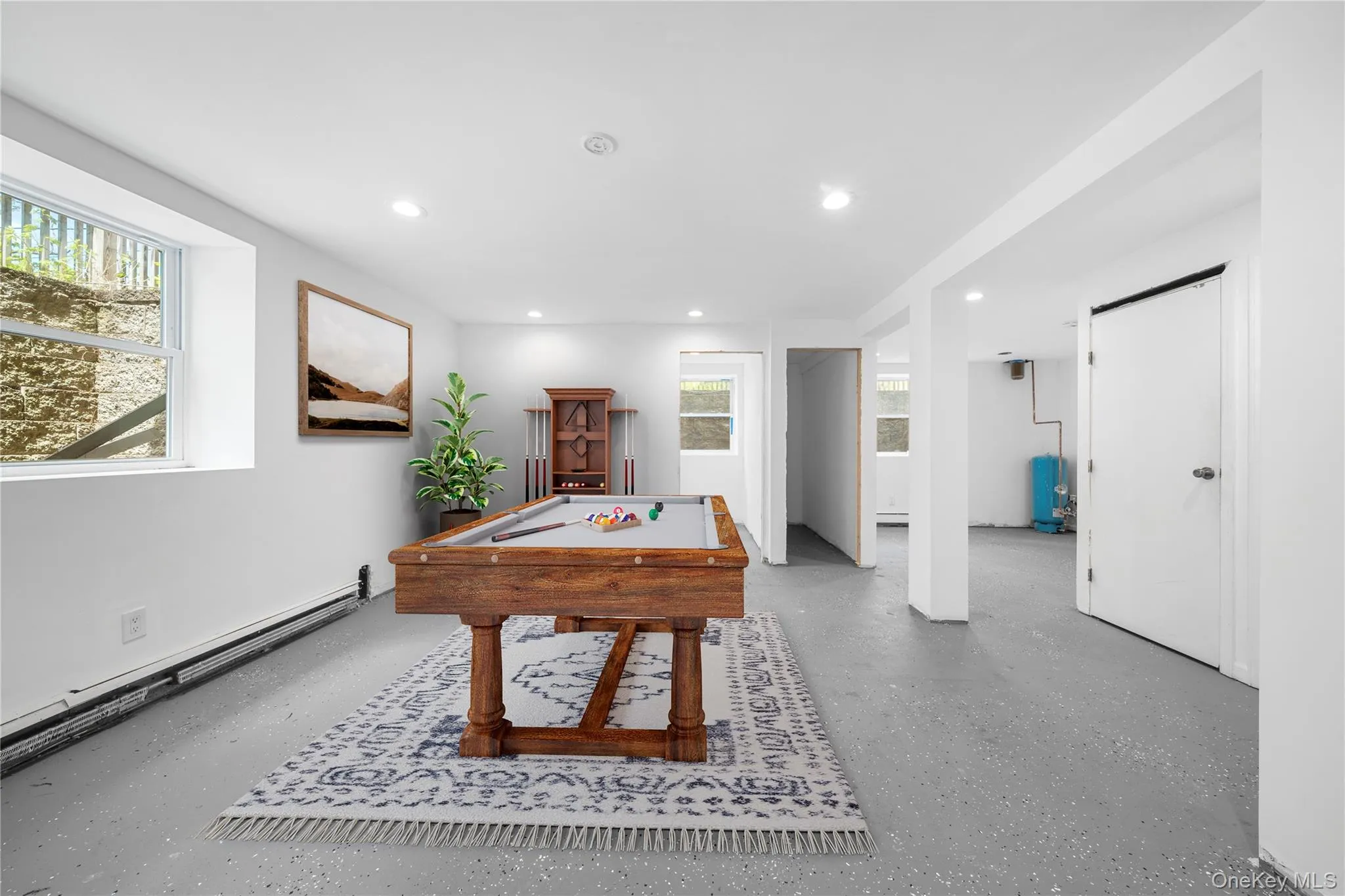 Brightly lit lower level featuring recessed lighting, a neutral color palette, durable epoxy flooring, and multiple egress windows. Image is Virtually Staged. Brightly lit lower level featuring recessed lighting, a neutral color palette, durable epoxy flooring, and multiple egress windows. Image is Virtually Staged.