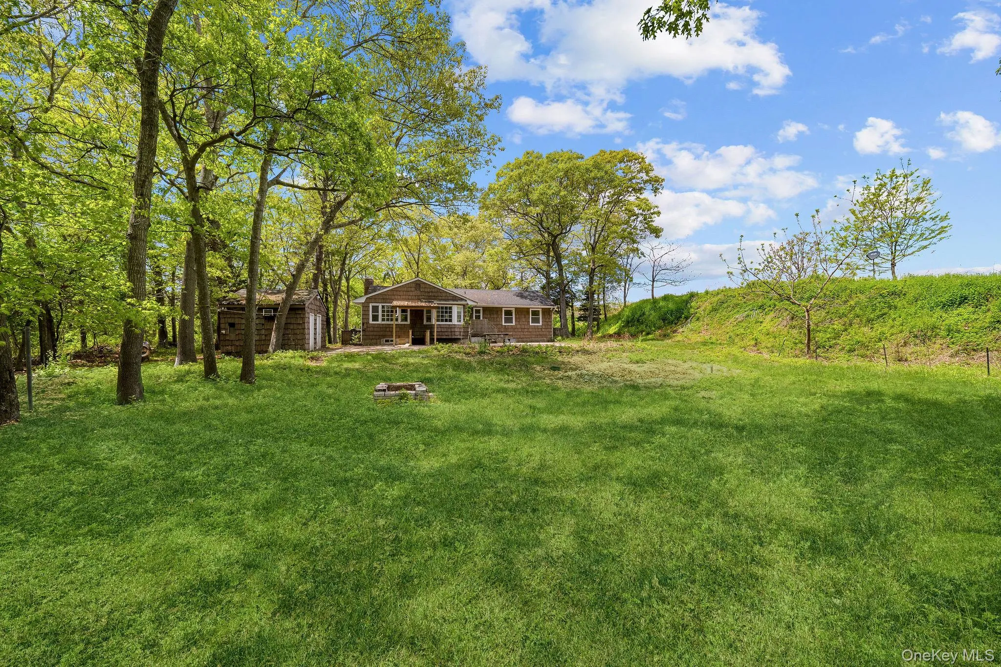 Expansive lawn area featuring a stone fire pit Expansive lawn area featuring a stone fire pit