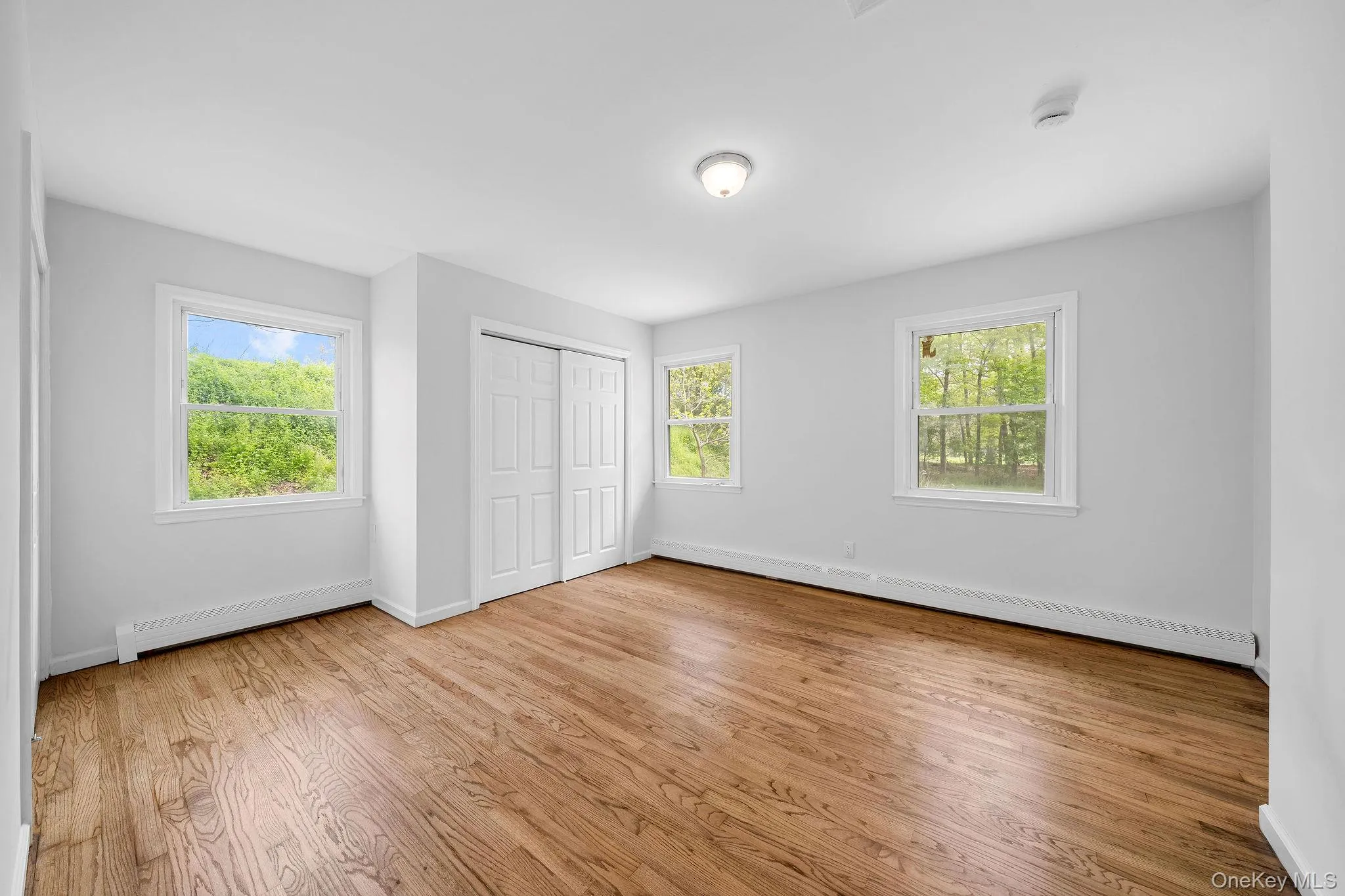 Room featuring rich wood-finish flooring and light gray walls Room featuring rich wood-finish flooring and light gray walls