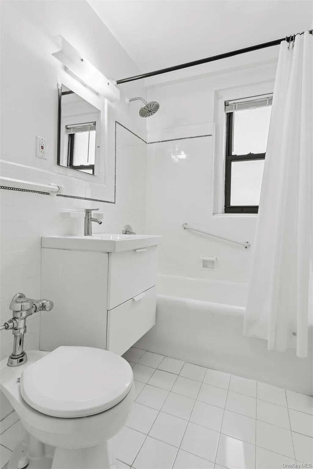 Full bathroom featuring white tile flooring, a wall-mounted vanity with integrated sink, a soaking tub with a rain shower head, and a window for natural light. Full bathroom featuring white tile flooring, a wall-mounted vanity with integrated sink, a soaking tub with a rain shower head, and a window for natural light.