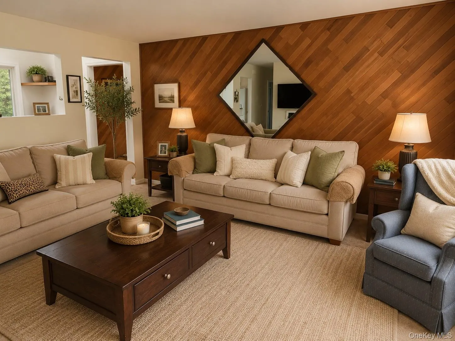 Living room diagonal wood accent wall with a diamond-shaped mirror, two sofas, an arm chair, coffee table, light color carpet and a view through into kitchenDigitally staged living room showing upgrade options Living room diagonal wood accent wall with a diamond-shaped mirror, two sofas, an arm chair, coffee table, light color carpet and a view through into kitchenDigitally staged living room showing upgrade options