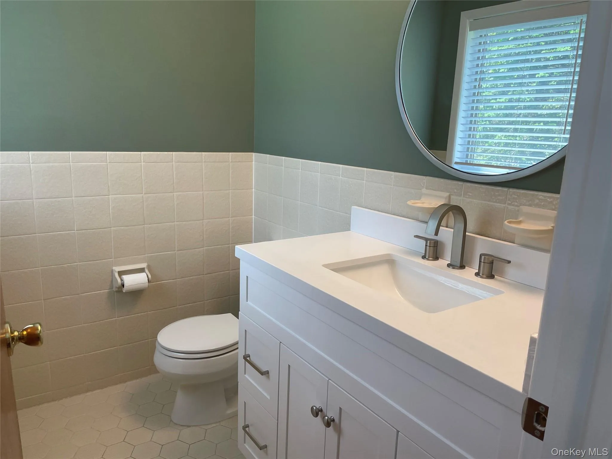 Bathroom with vanity, tile patterned flooring, and tile walls Bathroom with vanity, tile patterned flooring, and tile walls