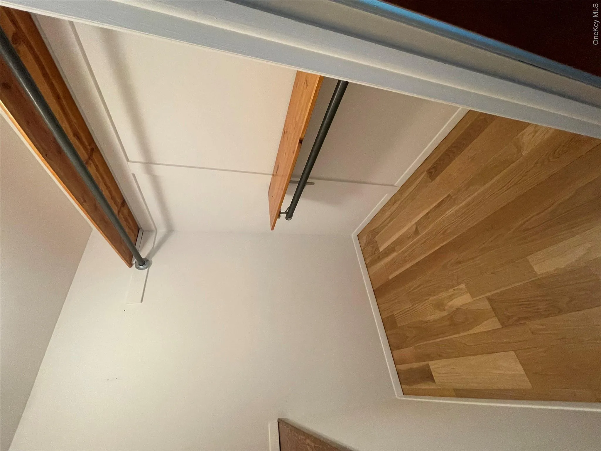 Walk in closet featuring wood finished floors Walk in closet featuring wood finished floors