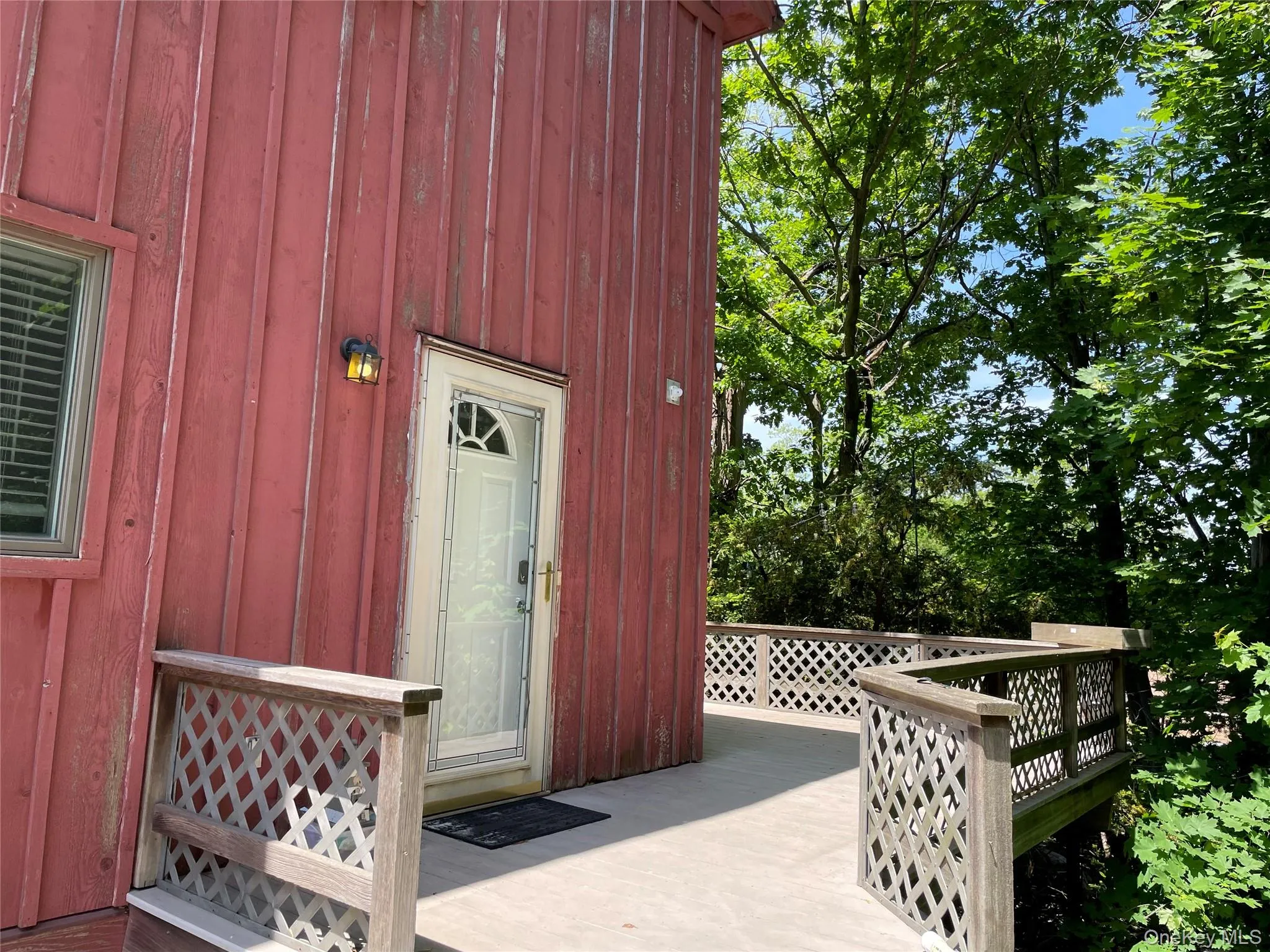 Entrance to property featuring a wooden deck and board and batten siding Entrance to property featuring a wooden deck and board and batten siding