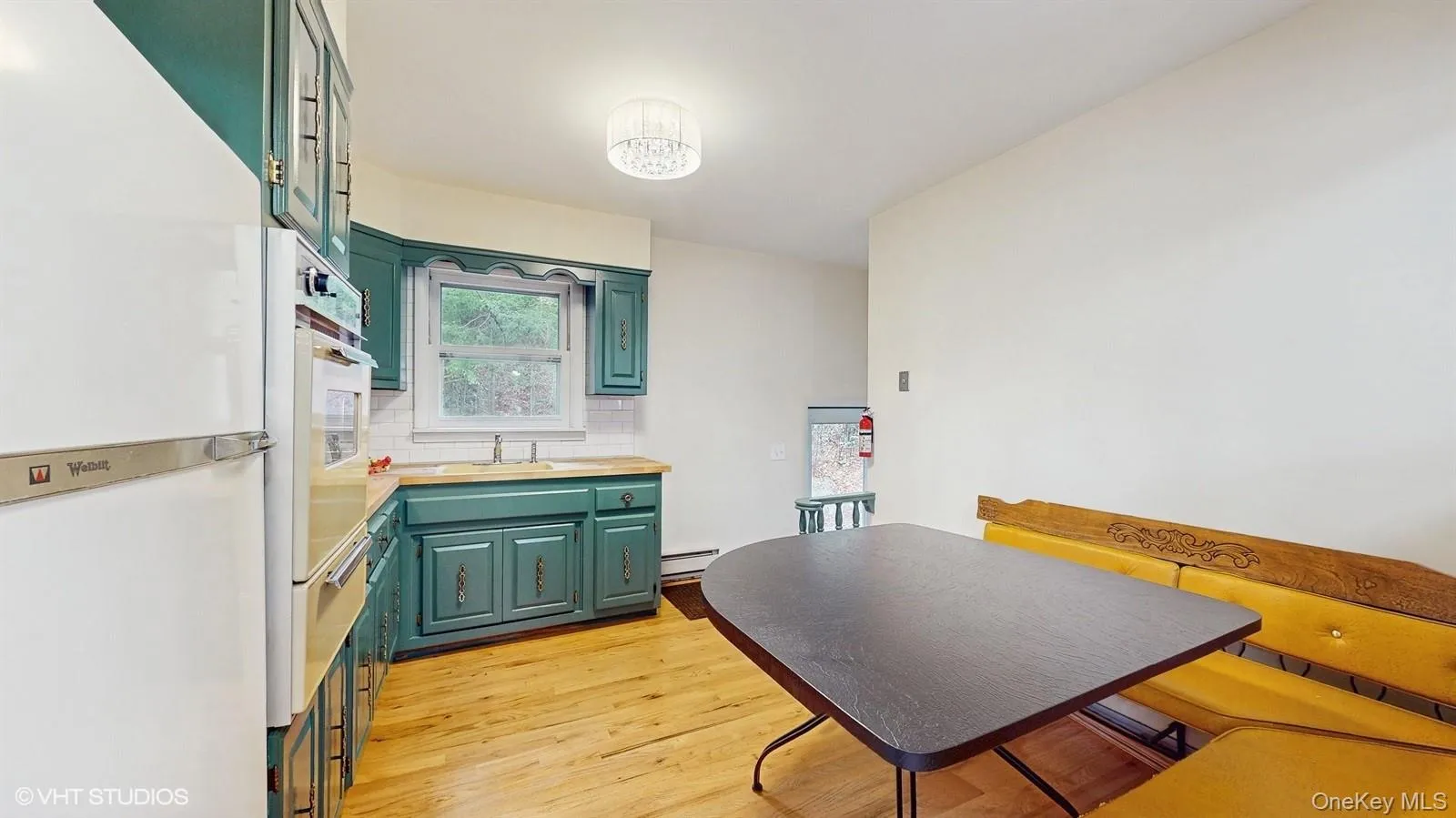 Kitchen with green cabinetry and light wood finished floors Kitchen with green cabinetry and light wood finished floors