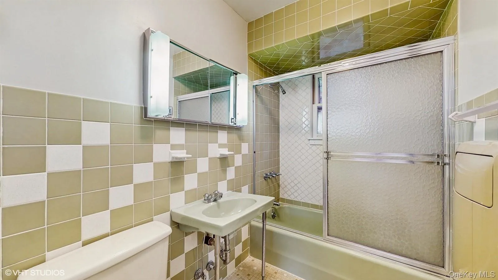 Bathroom with tile walls, and bath / shower combo with glass door Bathroom with tile walls, and bath / shower combo with glass door