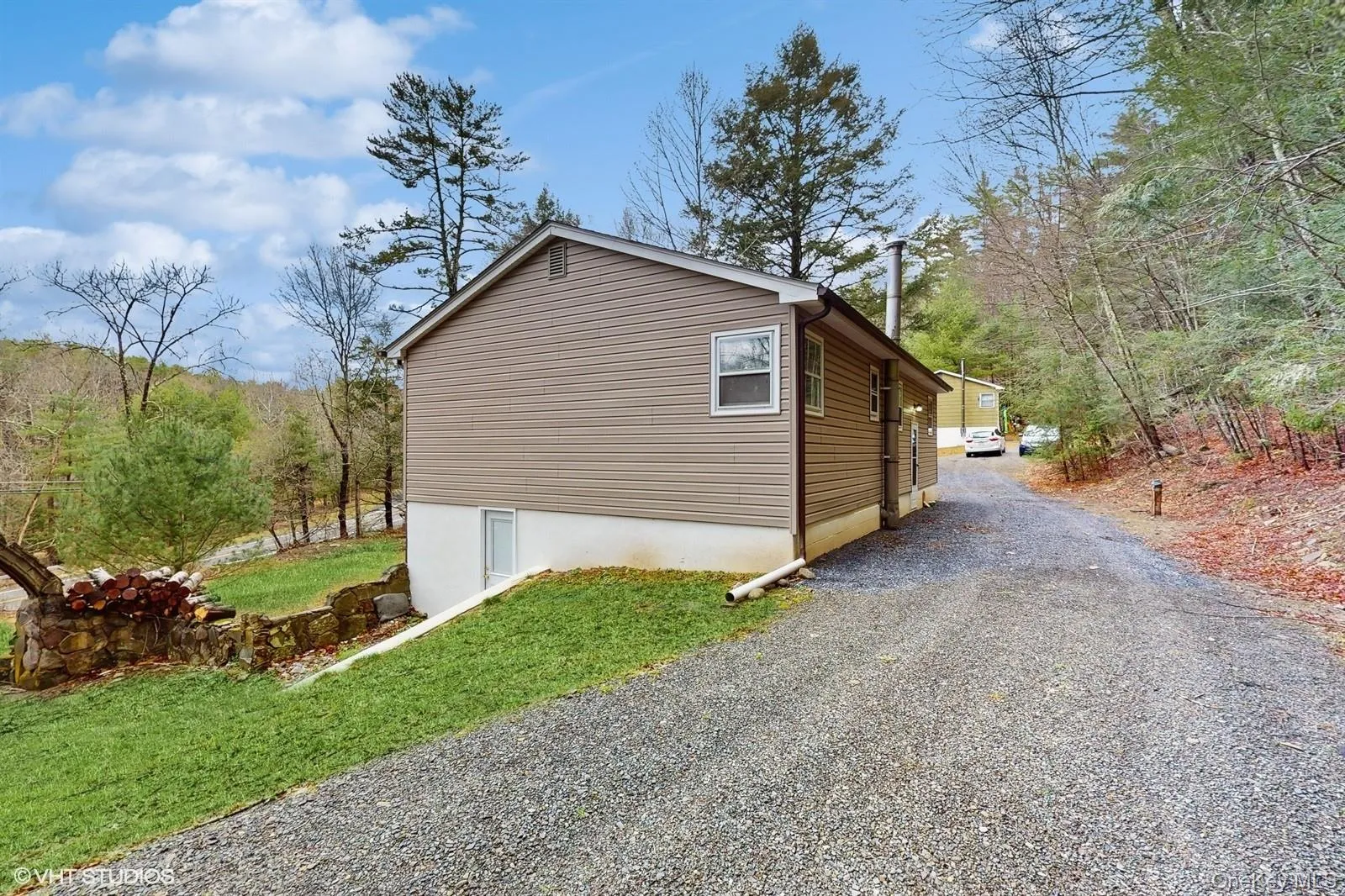 View of property exterior with a yard and driveway View of property exterior with a yard and driveway