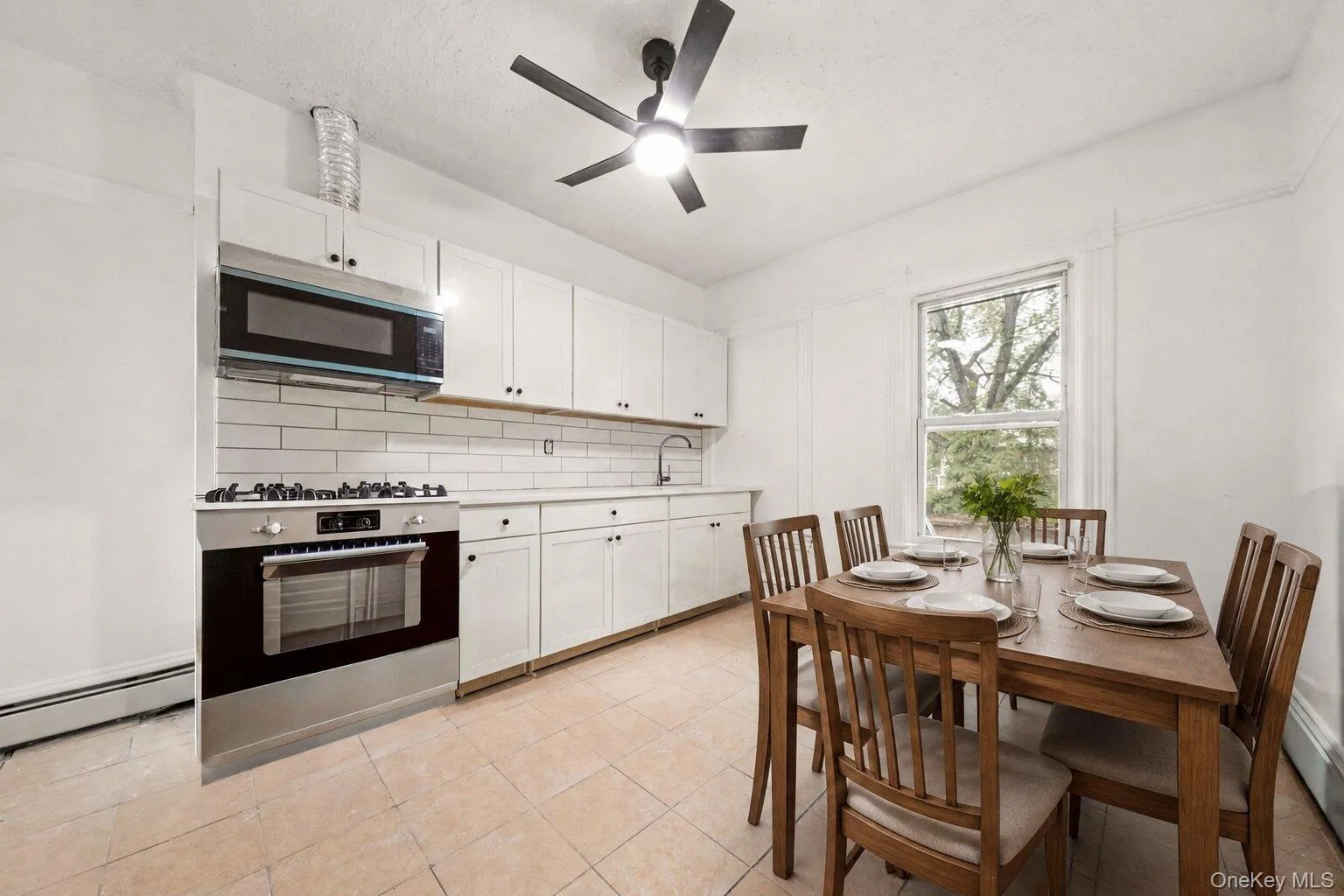 Virtually staged.Spacious eat-in kitchen featuring white shaker cabinetry, subway tile backsplash, stainless steel appliances, and plenty of room for dining and entertaining. Virtually staged.Spacious eat-in kitchen featuring white shaker cabinetry, subway tile backsplash, stainless steel appliances, and plenty of room for dining and entertaining.