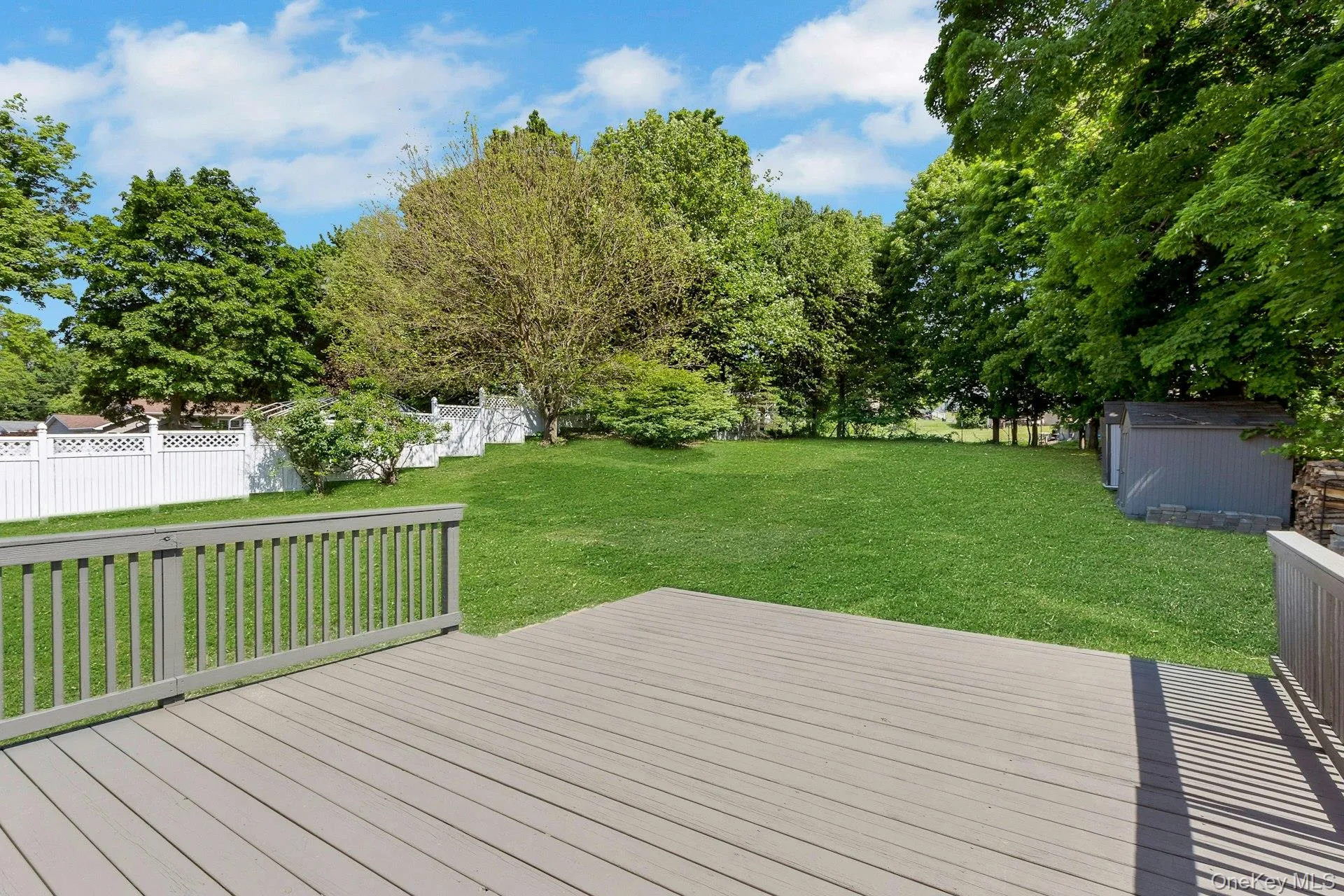 Deck and large level yard with sheds Deck and large level yard with sheds