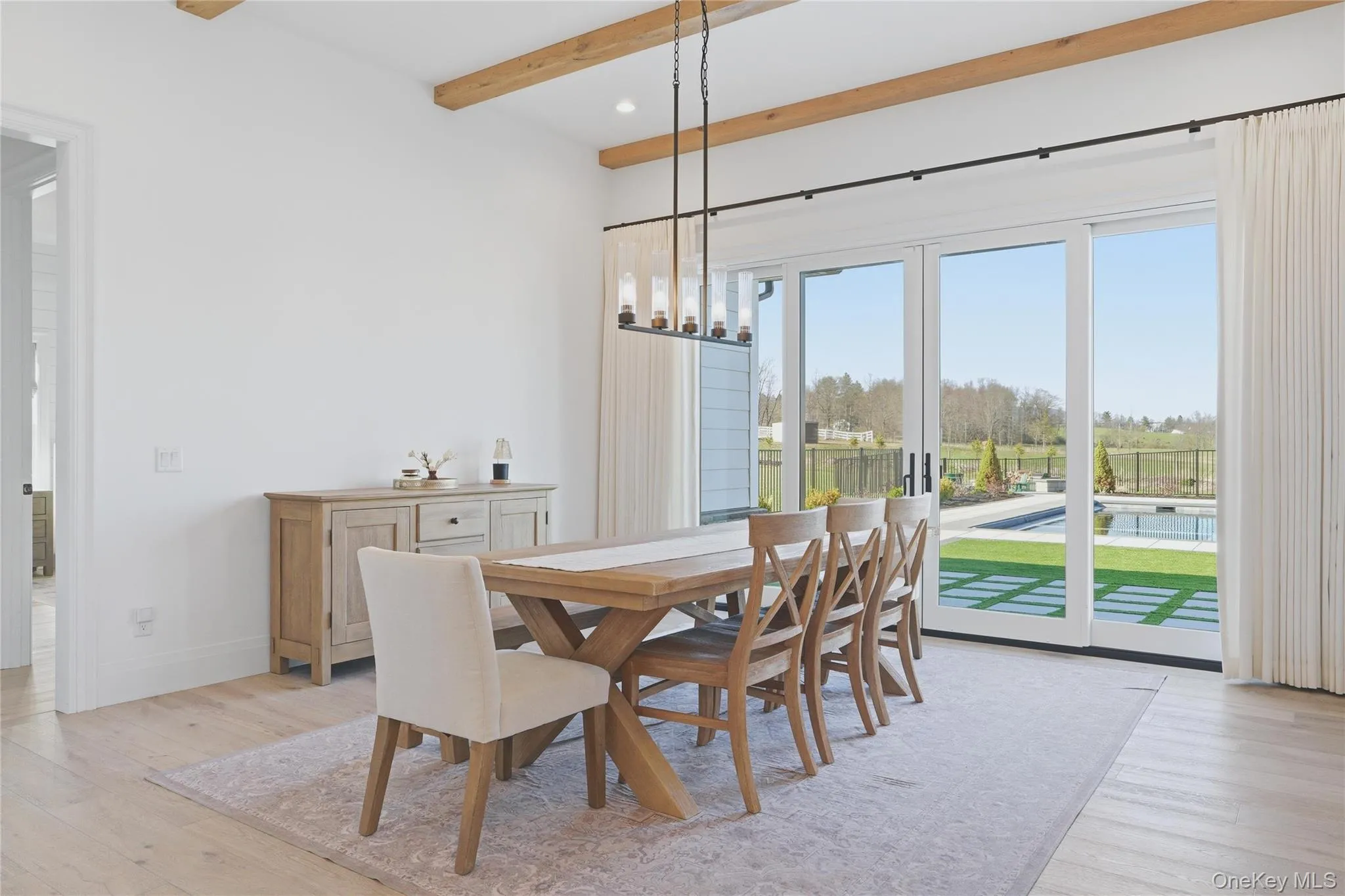 Dining area with wood-finish flooring and exposed ceiling beams Dining area with wood-finish flooring and exposed ceiling beams
