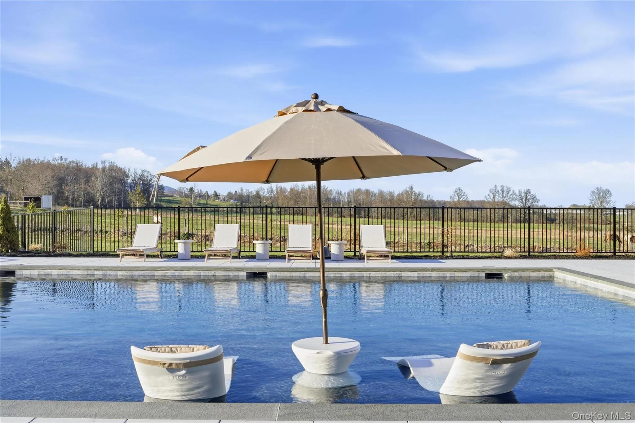 Inground swimming pool with a stone coping and a paved surround Inground swimming pool with a stone coping and a paved surround
