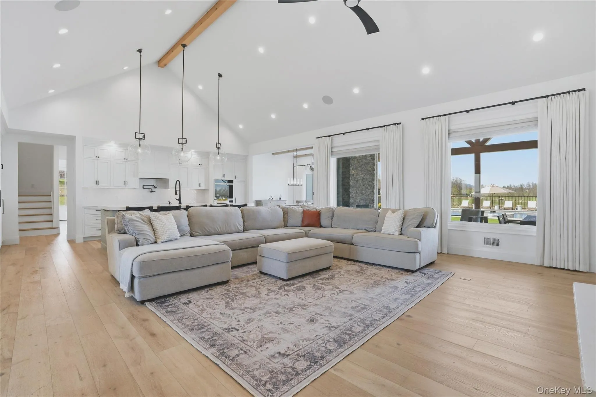Vaulted ceiling with an exposed wood beam, recessed lighting, and light wood-finish flooring Vaulted ceiling with an exposed wood beam, recessed lighting, and light wood-finish flooring
