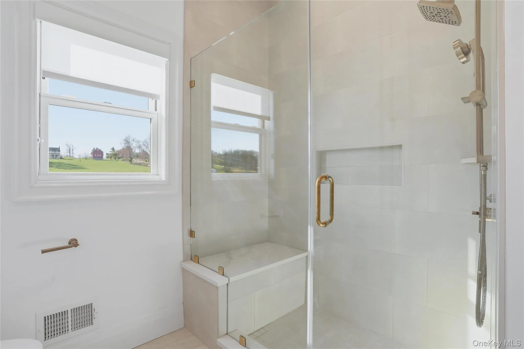 Frameless glass shower enclosure featuring a built-in bench, recessed shelf, and multi-function showerhead Frameless glass shower enclosure featuring a built-in bench, recessed shelf, and multi-function showerhead