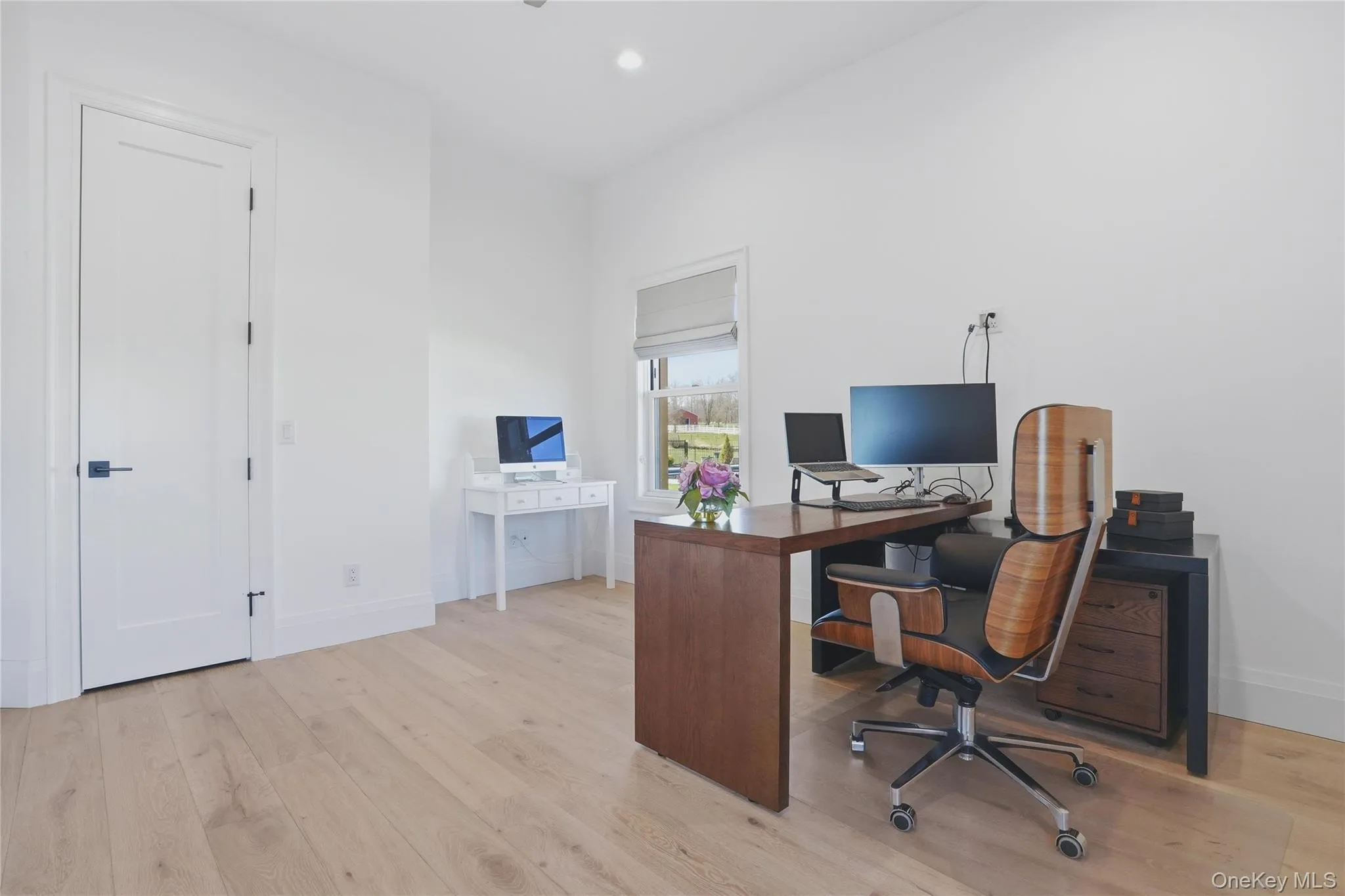 Bright room with light wood-finish flooring and a white color palette Bright room with light wood-finish flooring and a white color palette