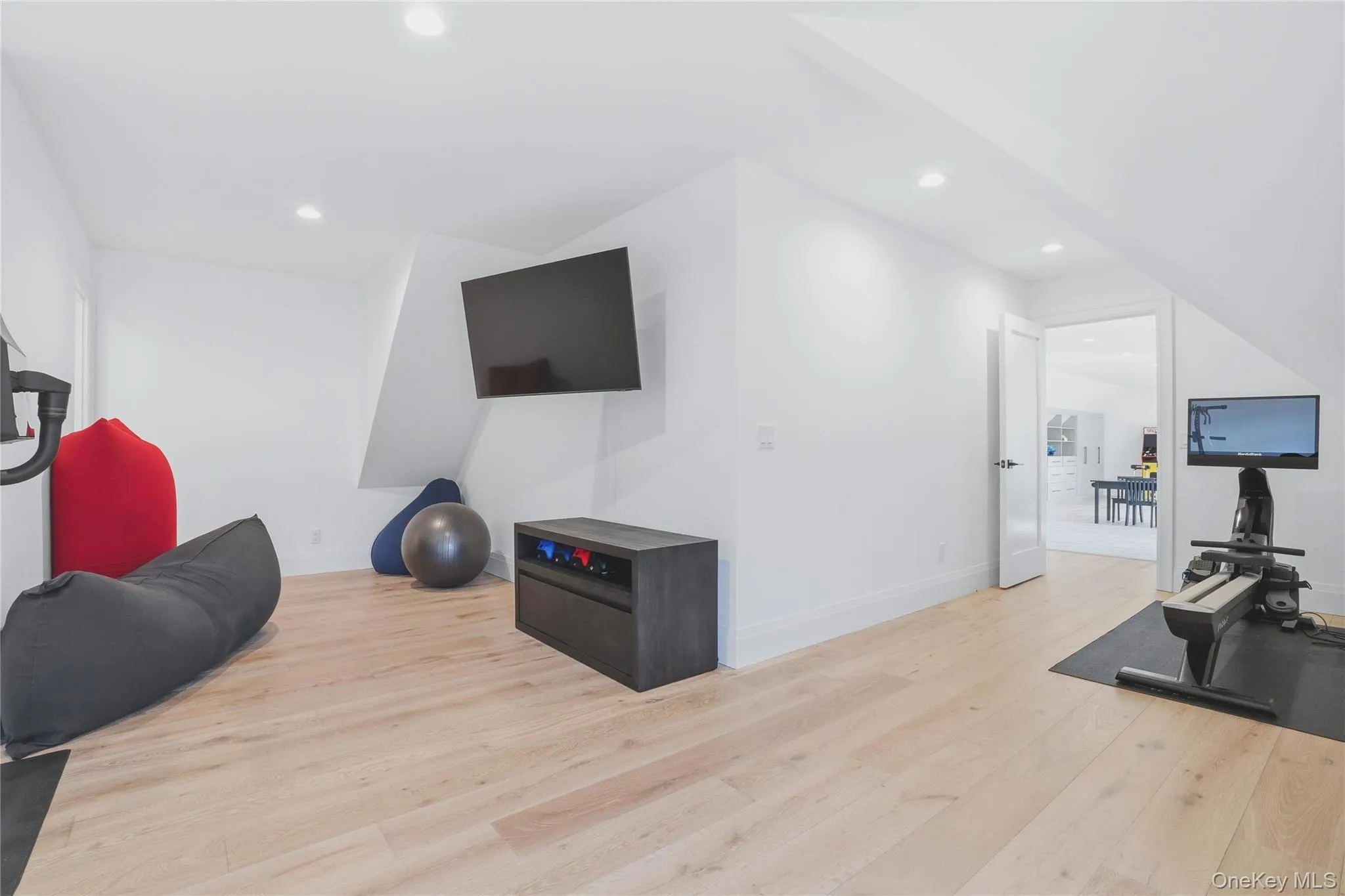 Versatile bonus room featuring light wood-finish flooring, recessed lighting, and crisp white walls Versatile bonus room featuring light wood-finish flooring, recessed lighting, and crisp white walls