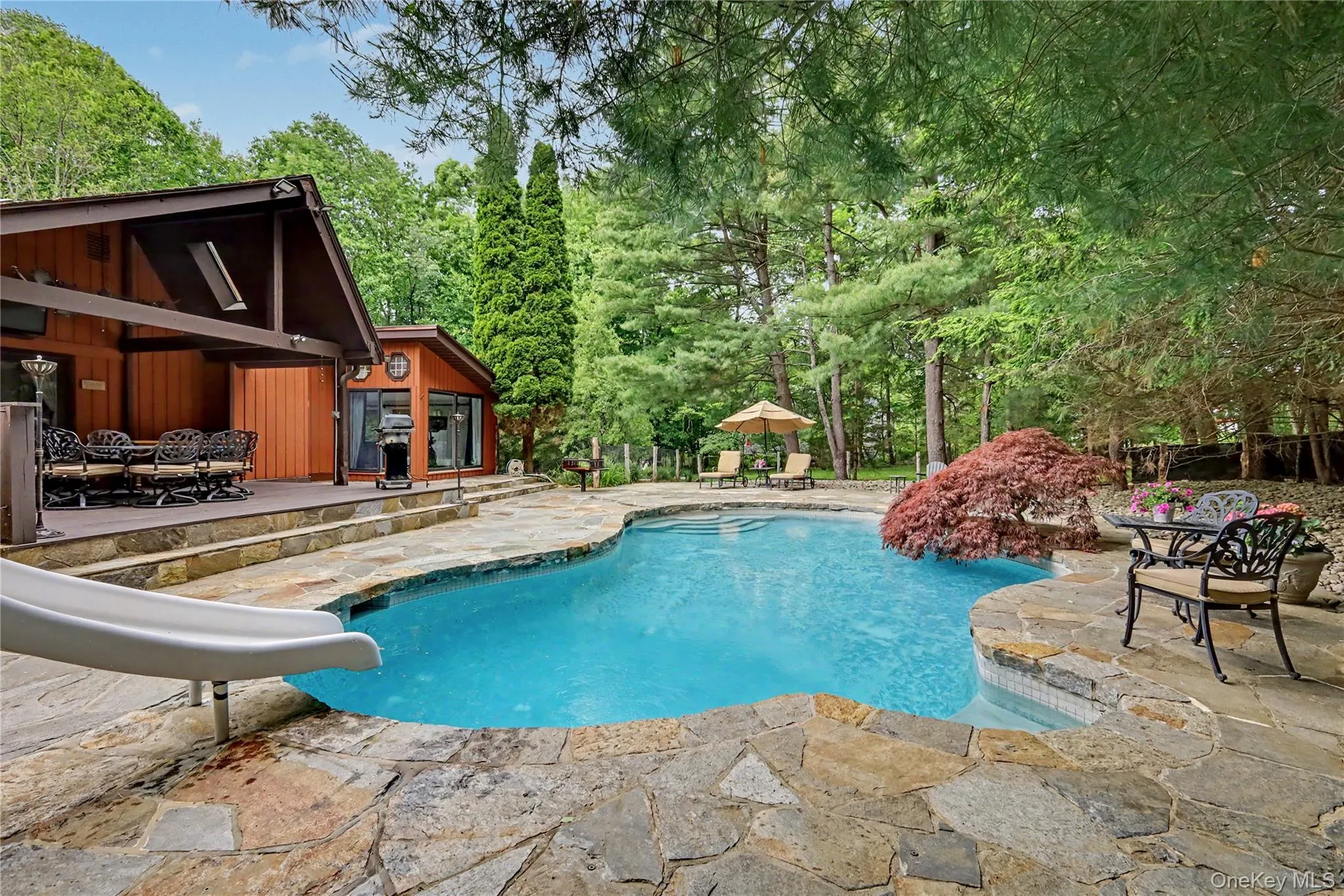 Gunite heated pool with slide surrounded by Westchester Granite stone patio. Gunite heated pool with slide surrounded by Westchester Granite stone patio.