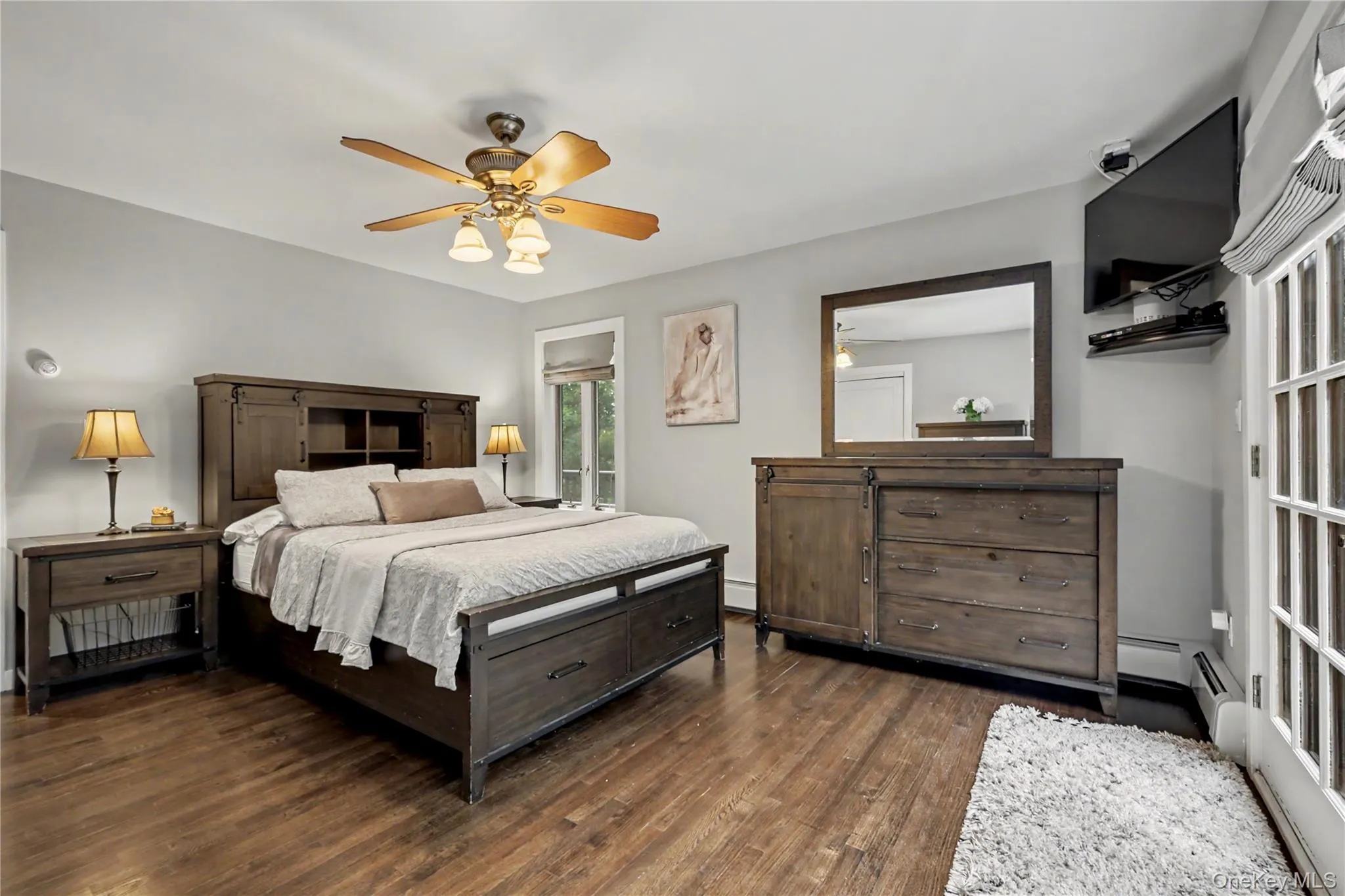 Primary bedroom with French doors leading to wraparound deck. Primary bedroom with French doors leading to wraparound deck.