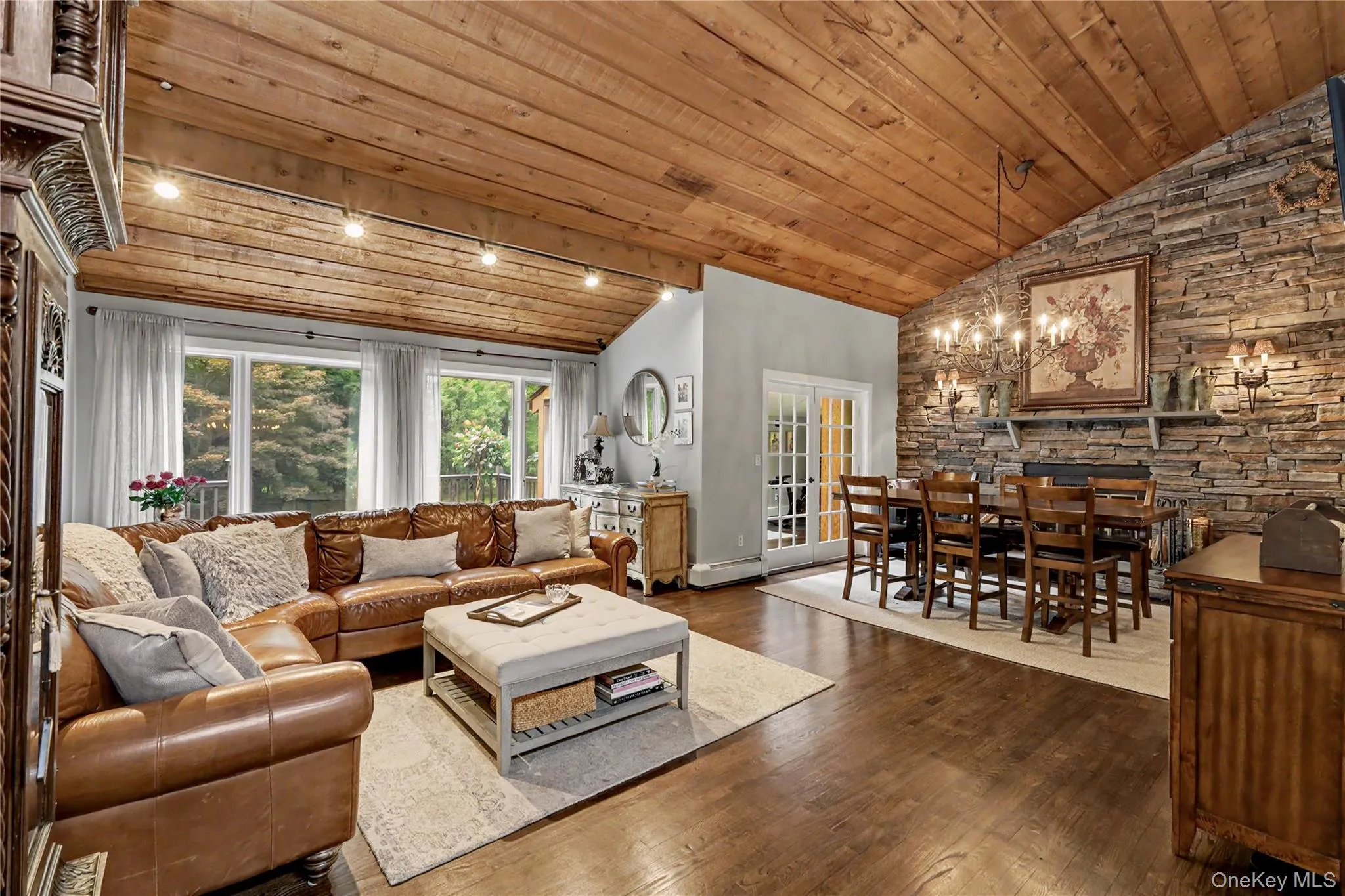 Dramatic living/dining room with vaulted cedar ceilings and stone walled fireplace. Dramatic living/dining room with vaulted cedar ceilings and stone walled fireplace.