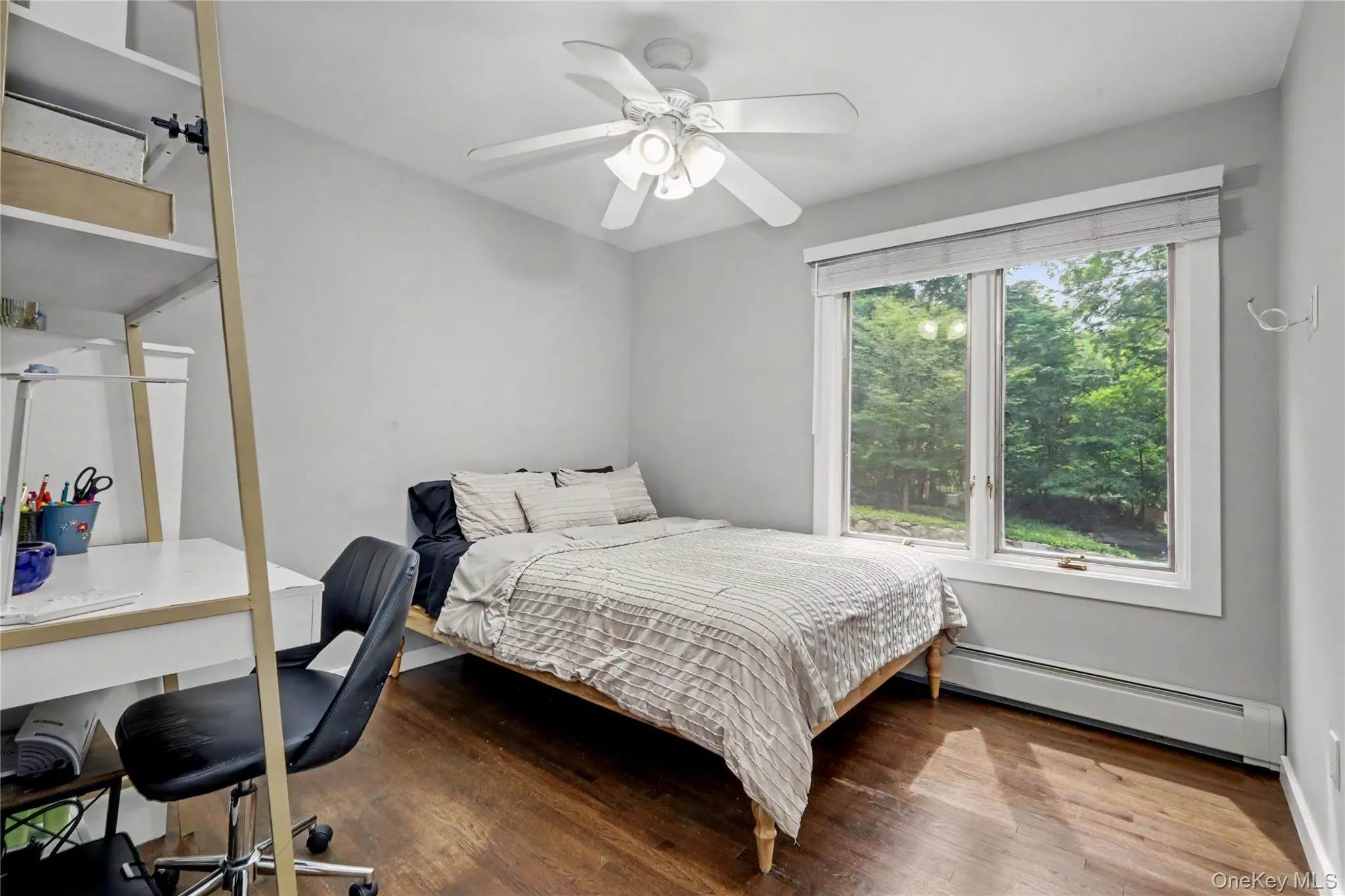 Main floor bedroom with ceiling fan and hardwood floors. Main floor bedroom with ceiling fan and hardwood floors.