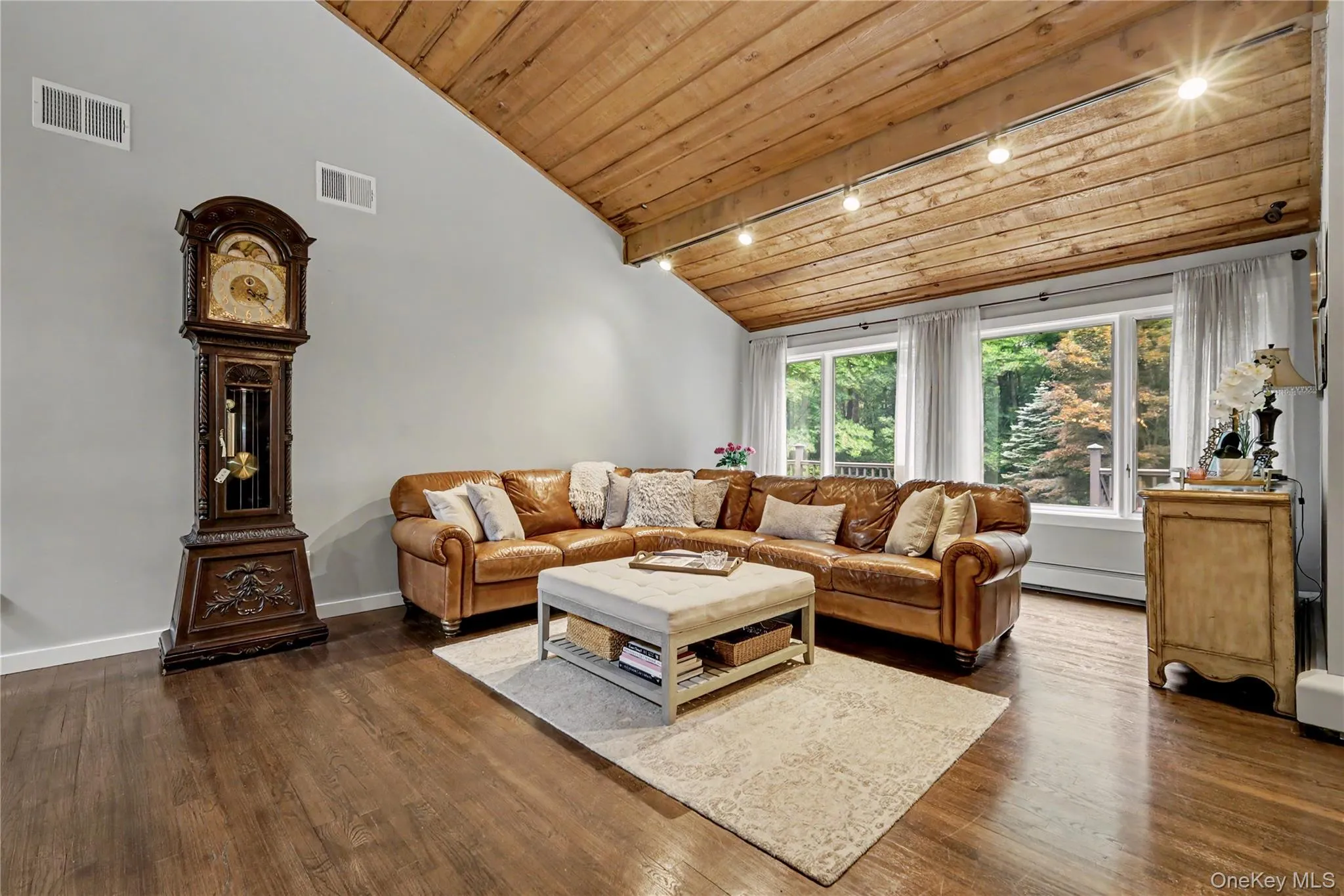 Bright sun filled living room with vaulted cedar ceiling and hardwood floors. Bright sun filled living room with vaulted cedar ceiling and hardwood floors.