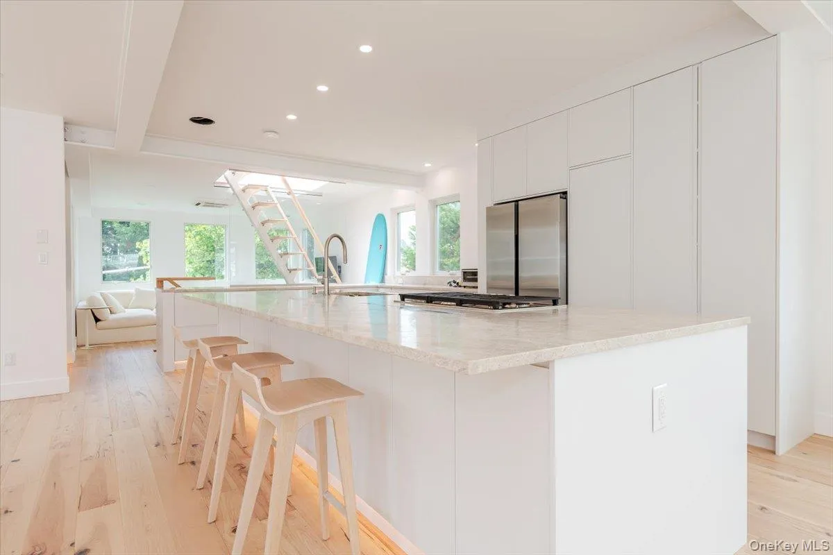 Kitchen featuring stainless steel fridge, recessed lighting, open floor plan, light wood-style flooring, and a spacious island Kitchen featuring stainless steel fridge, recessed lighting, open floor plan, light wood-style flooring, and a spacious island