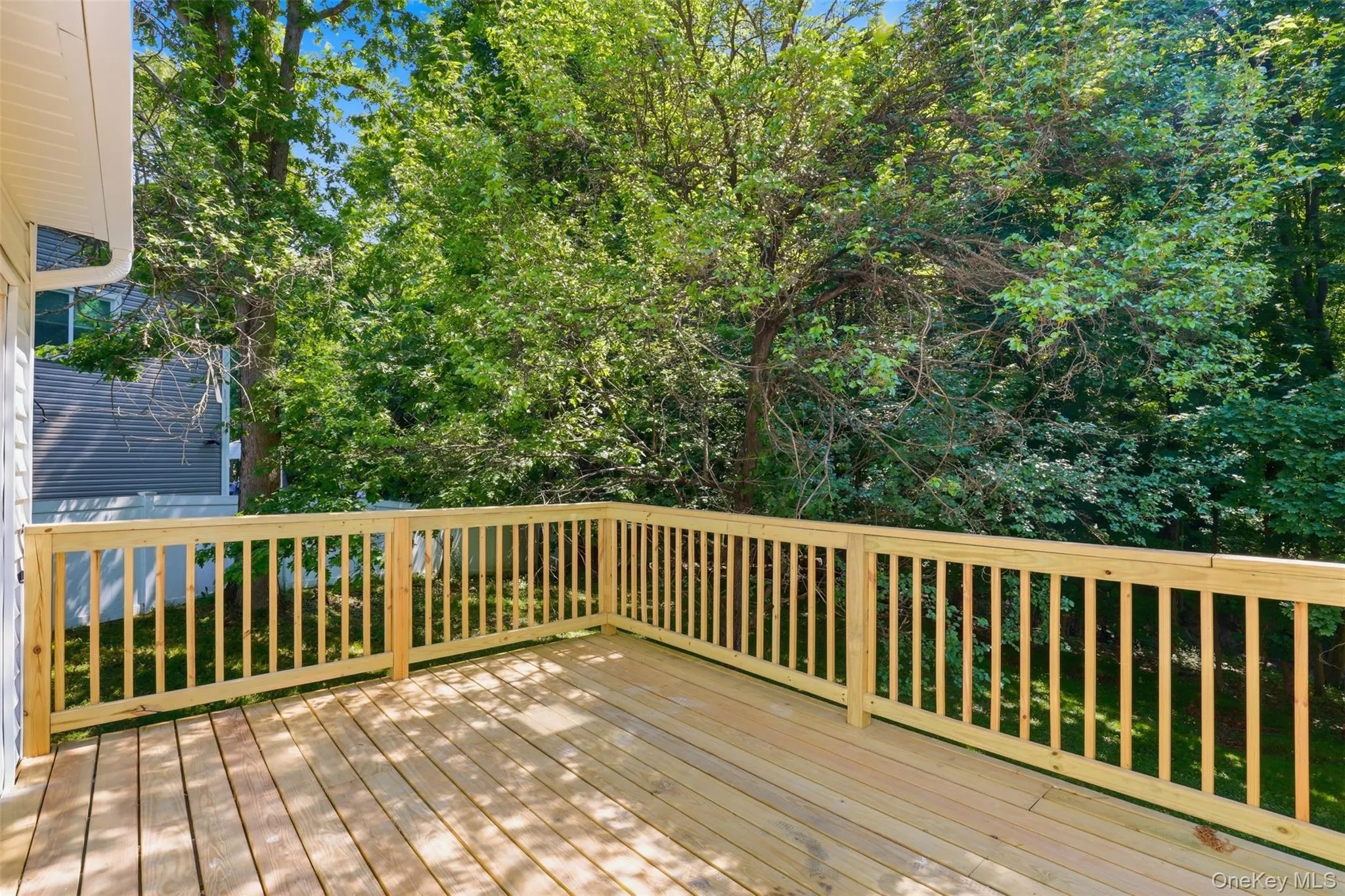 Expansive wooden deck featuring horizontal plank flooring and a wood railing system Expansive wooden deck featuring horizontal plank flooring and a wood railing system