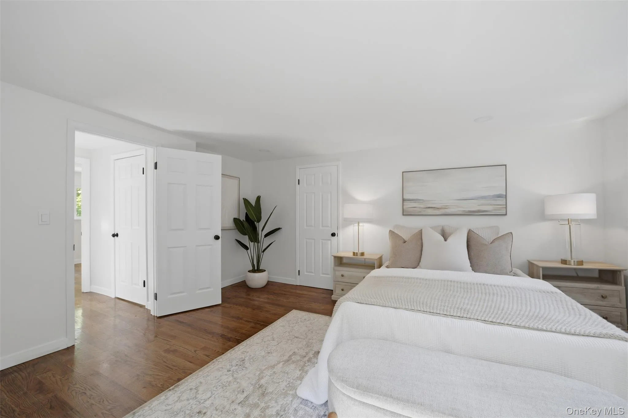 Bright room featuring wood-finish flooring, white walls, and recessed lighting Bright room featuring wood-finish flooring, white walls, and recessed lighting