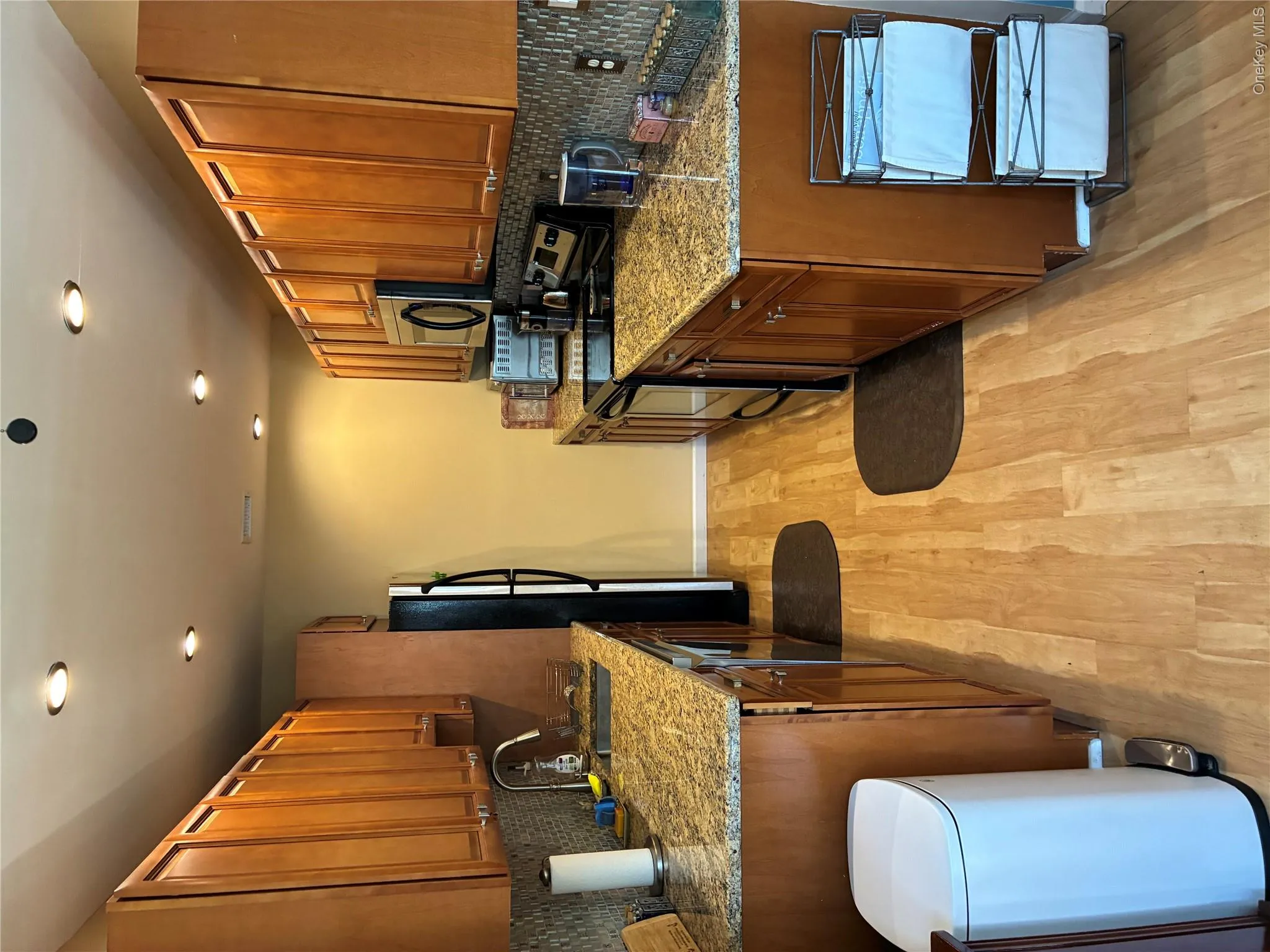 Updated Galley kitchen with plenty of cabinets for storage. View shows appliances-Frig and electric stove towards rear area on opposite sides of each other. Also Full length size Granite Counter tops on both sides! Updated Galley kitchen with plenty of cabinets for storage. View shows appliances-Frig and electric stove towards rear area on opposite sides of each other. Also Full length size Granite Counter tops on both sides!