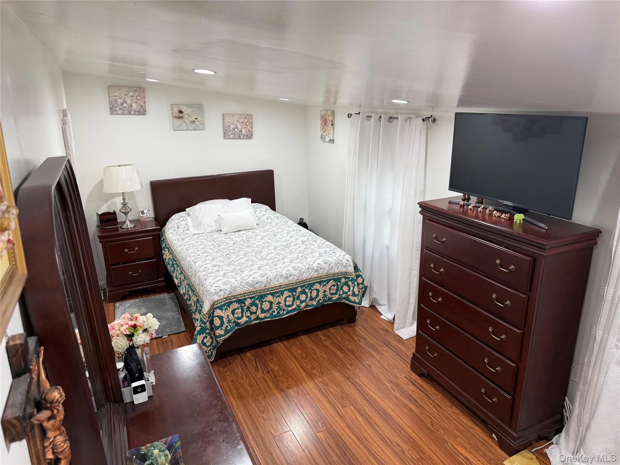 Bedroom space featuring wood-finish flooring, recessed lighting, and 2 windows. Bedroom space featuring wood-finish flooring, recessed lighting, and 2 windows.