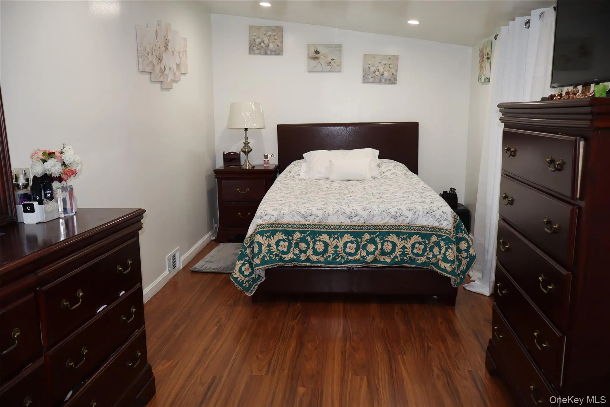 Wood-finish flooring paired with white baseboards, bright white walls, and recessed lighting Wood-finish flooring paired with white baseboards, bright white walls, and recessed lighting