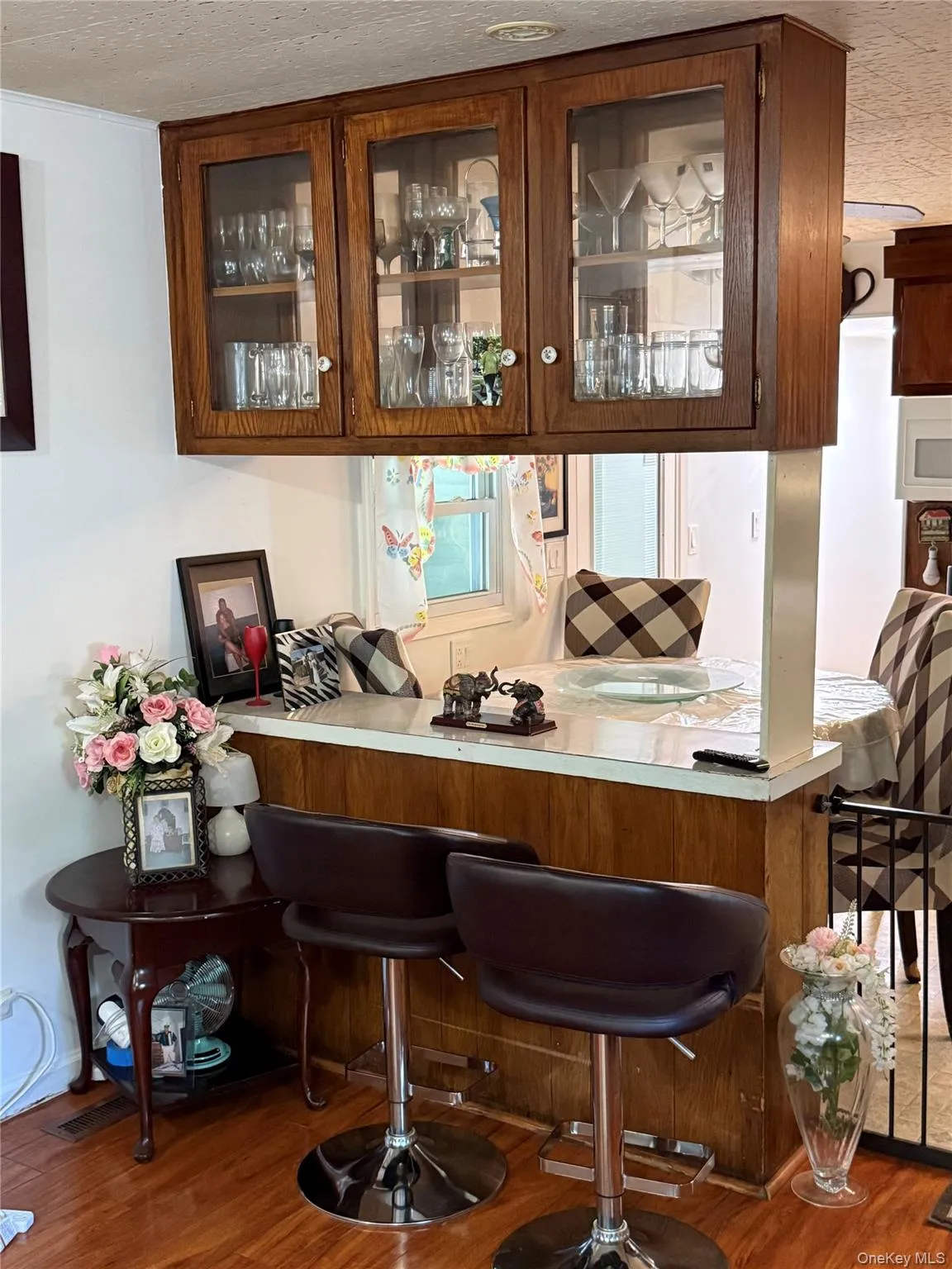 Wood-finish flooring complementing a breakfast bar with a white countertop Wood-finish flooring complementing a breakfast bar with a white countertop