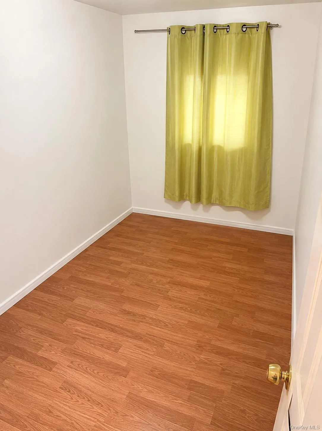 Bedroom 4 Neutral white walls and wood-finish flooring define this bright room, featuring white baseboards Bedroom 4 Neutral white walls and wood-finish flooring define this bright room, featuring white baseboards