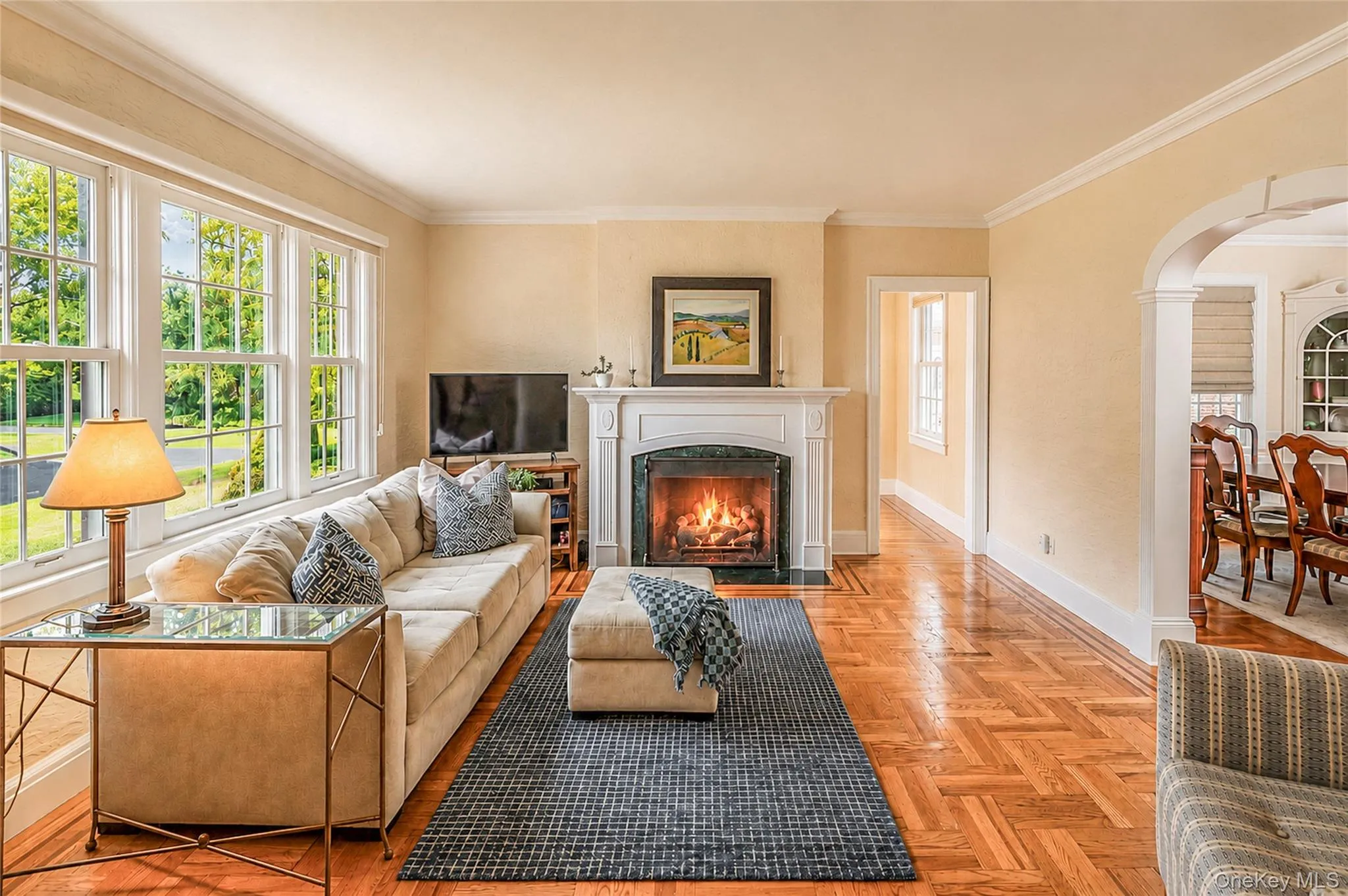 Sunlit Formal Living Room with gas fireplace flows into the Formal Dining Room and the Den. Sunlit Formal Living Room with gas fireplace flows into the Formal Dining Room and the Den.