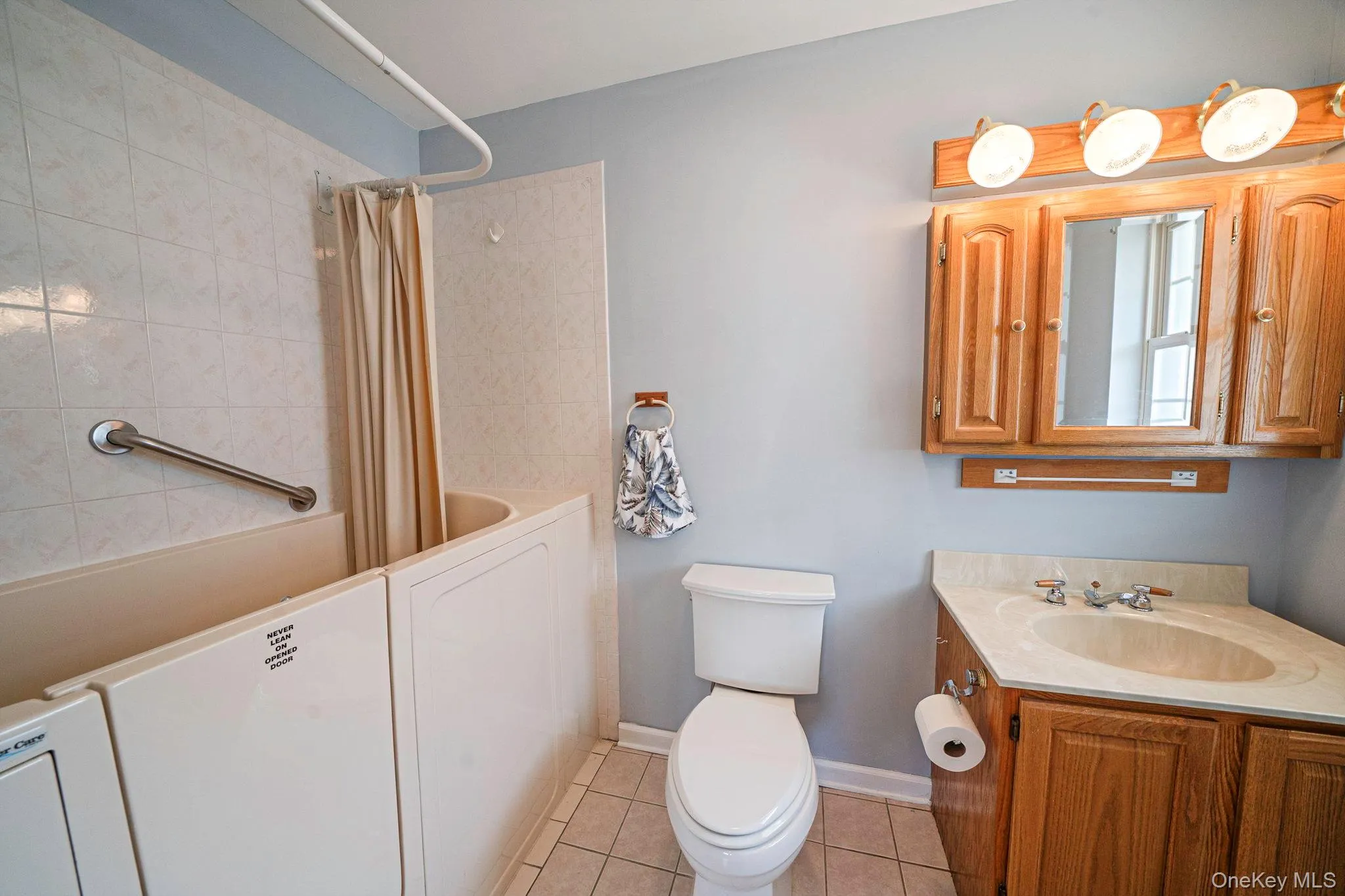 Tile floor, single sink vanity, walk in tub/shower Tile floor, single sink vanity, walk in tub/shower