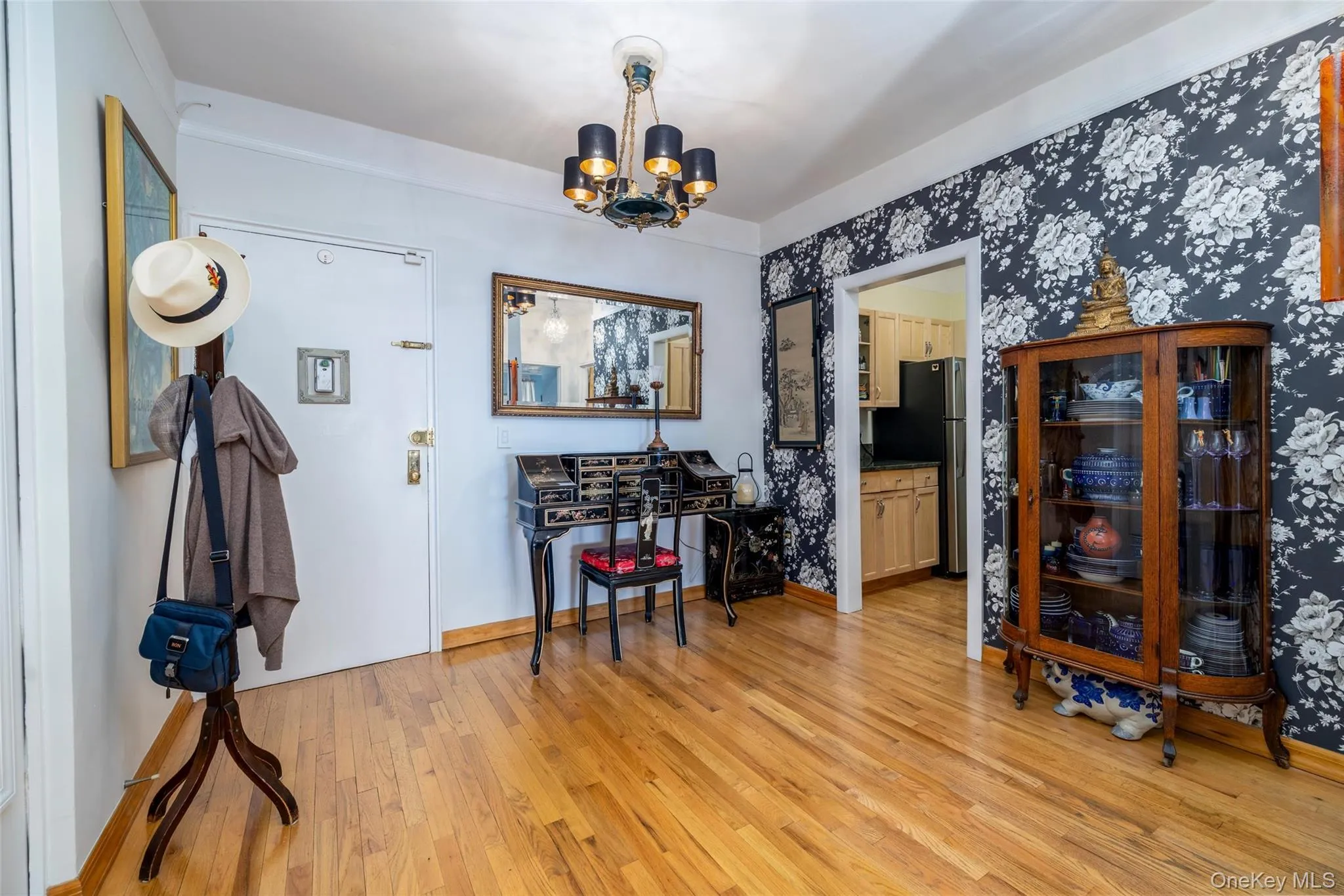 Entryway featuring wood-finish flooring, a decorative chandelier, and 2 wall to ceiling closets Entryway featuring wood-finish flooring, a decorative chandelier, and 2 wall to ceiling closets
