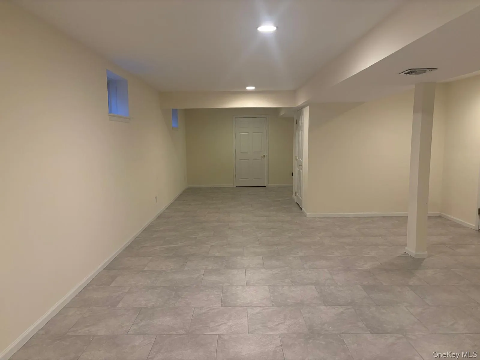 Spacious finished lower level featuring recessed lighting, light toned walls, contemporary gray tile flooring, and multiple window wells Spacious finished lower level featuring recessed lighting, light toned walls, contemporary gray tile flooring, and multiple window wells