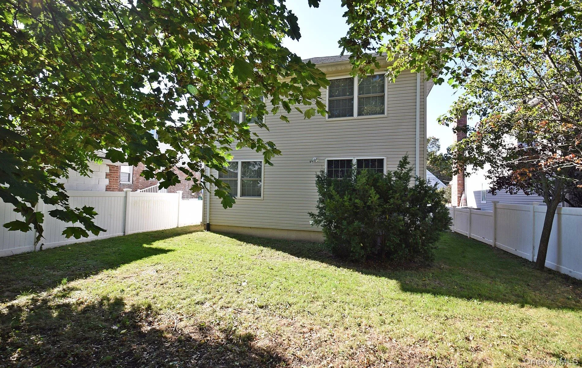 Expansive backyard featuring a manicured lawn, full privacy fencing, and mature trees providing natural shade. Expansive backyard featuring a manicured lawn, full privacy fencing, and mature trees providing natural shade.