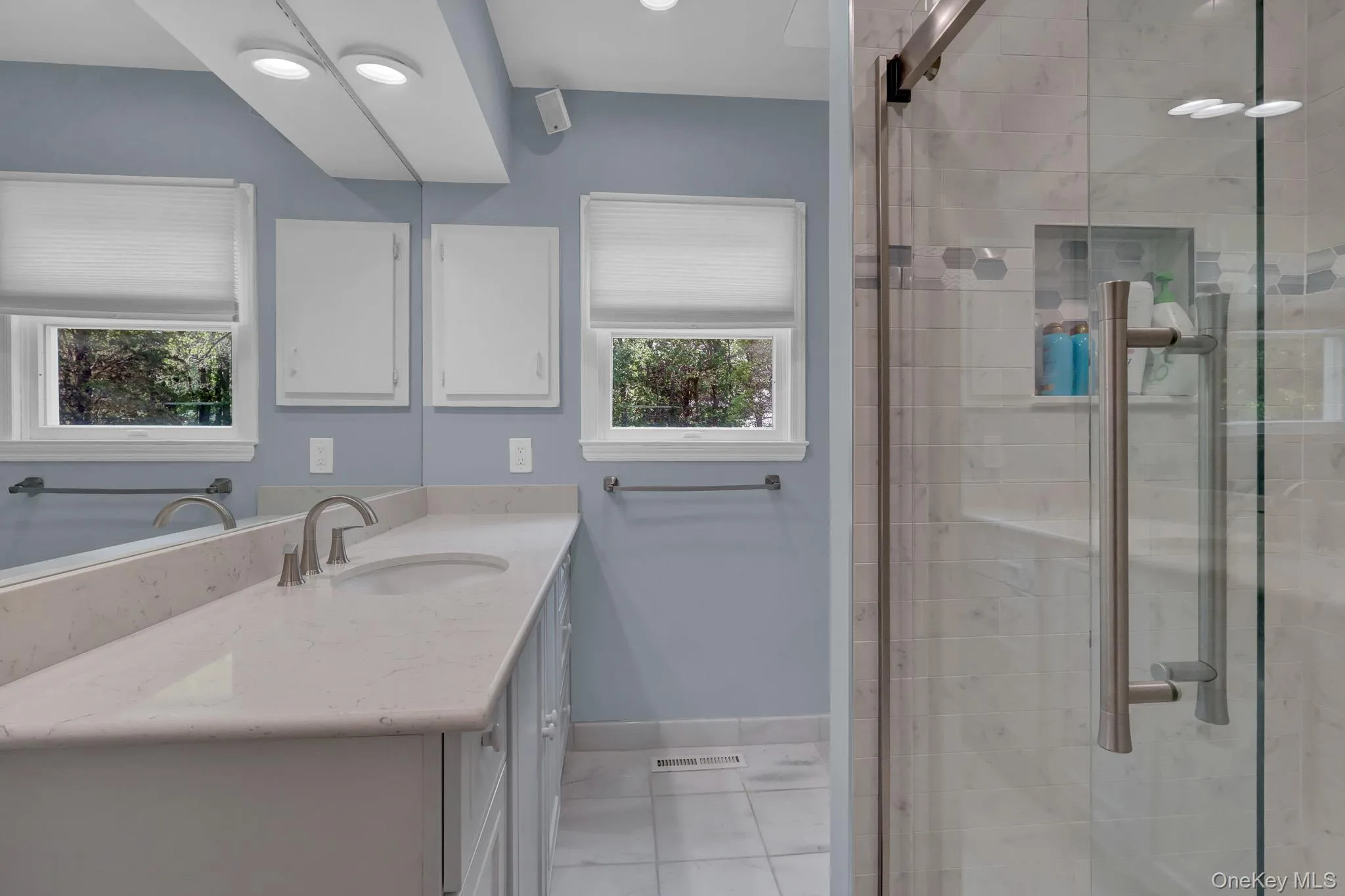 2nd primary Bathroom featuring a dual-sink vanity with a light-toned countertop, brushed nickel fixtures, and ample cabinetry 2nd primary Bathroom featuring a dual-sink vanity with a light-toned countertop, brushed nickel fixtures, and ample cabinetry