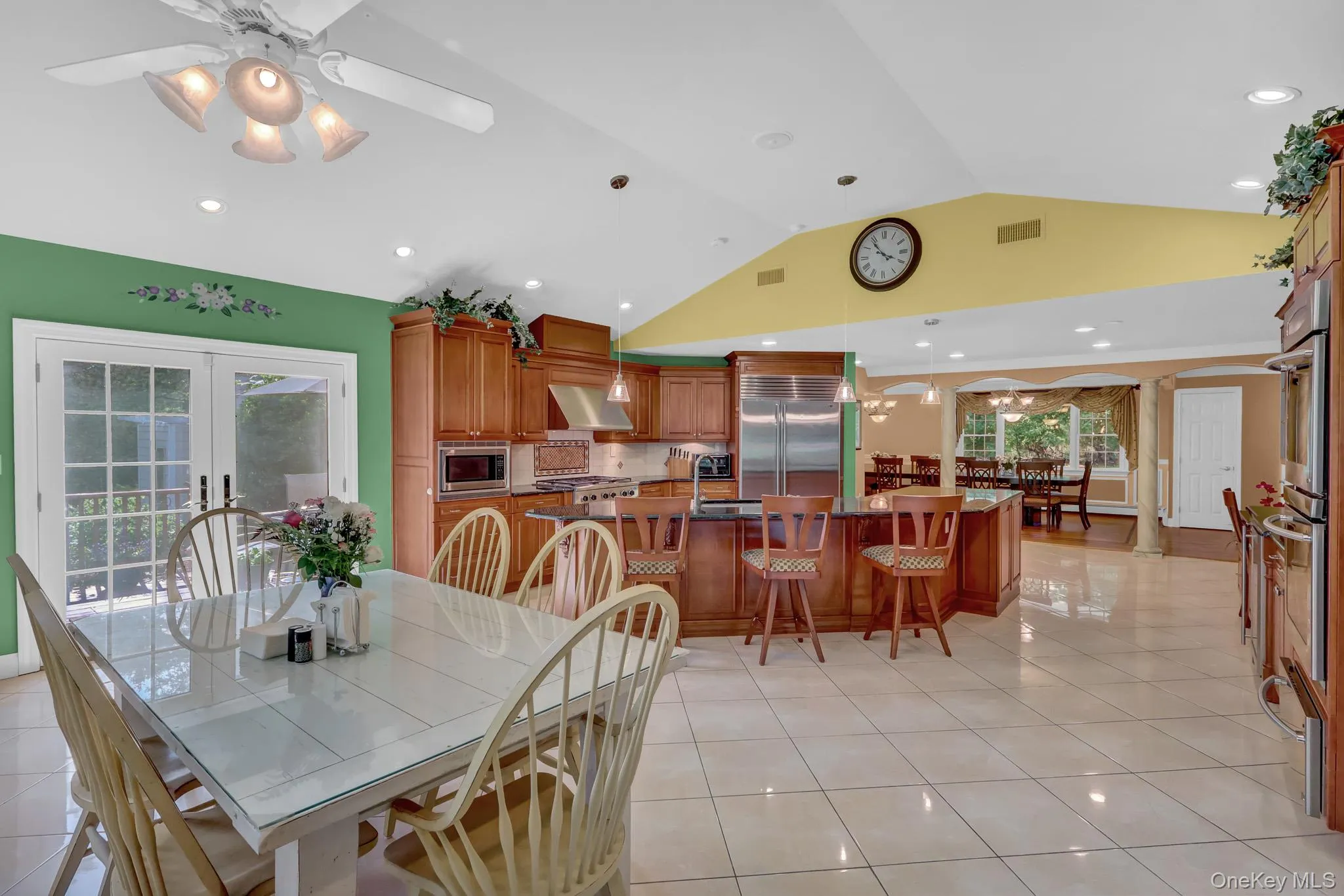 Spacious kitchen featuring warm-toned cabinetry, stainless steel appliances, and a central island with seating Spacious kitchen featuring warm-toned cabinetry, stainless steel appliances, and a central island with seating