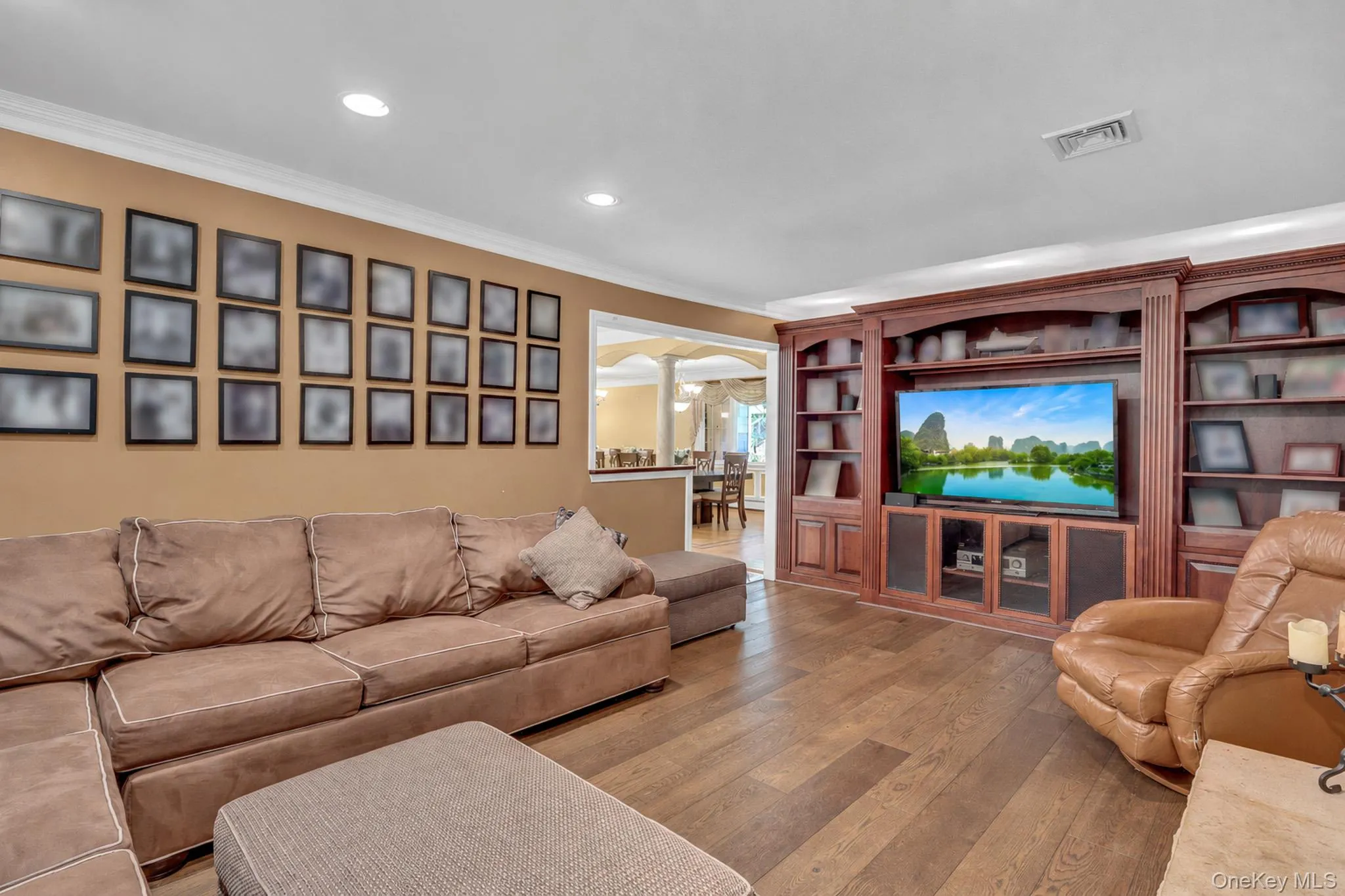 Living area featuring wood-finish flooring, recessed lighting, and crown molding Living area featuring wood-finish flooring, recessed lighting, and crown molding