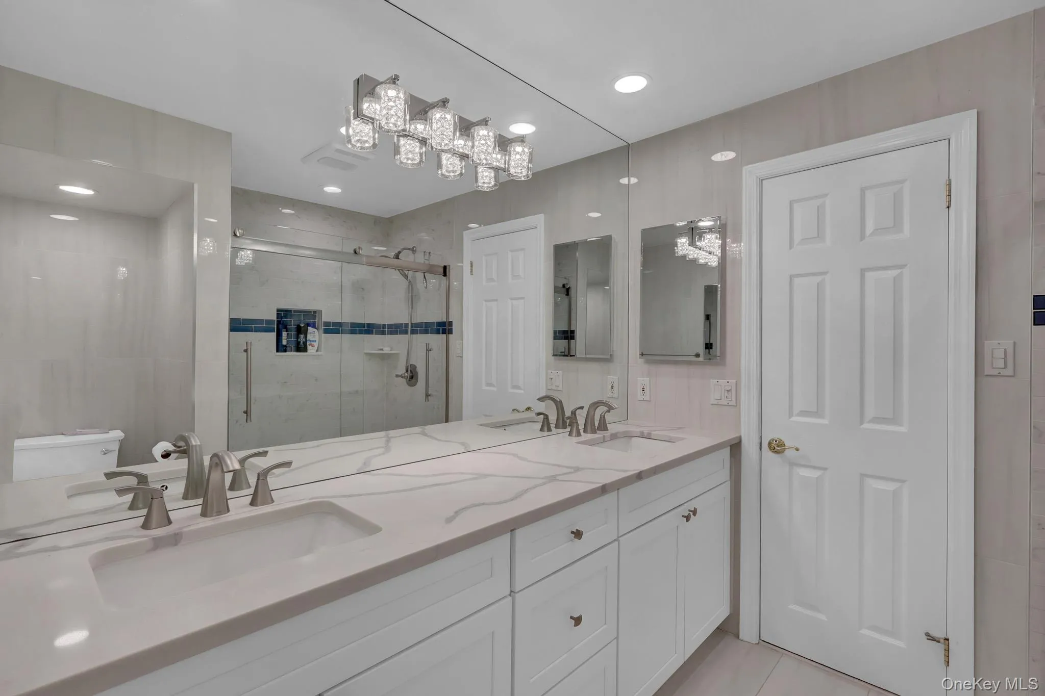 Dual vanity with integrated sinks, brushed nickel fixtures, and a light-toned countertop Dual vanity with integrated sinks, brushed nickel fixtures, and a light-toned countertop